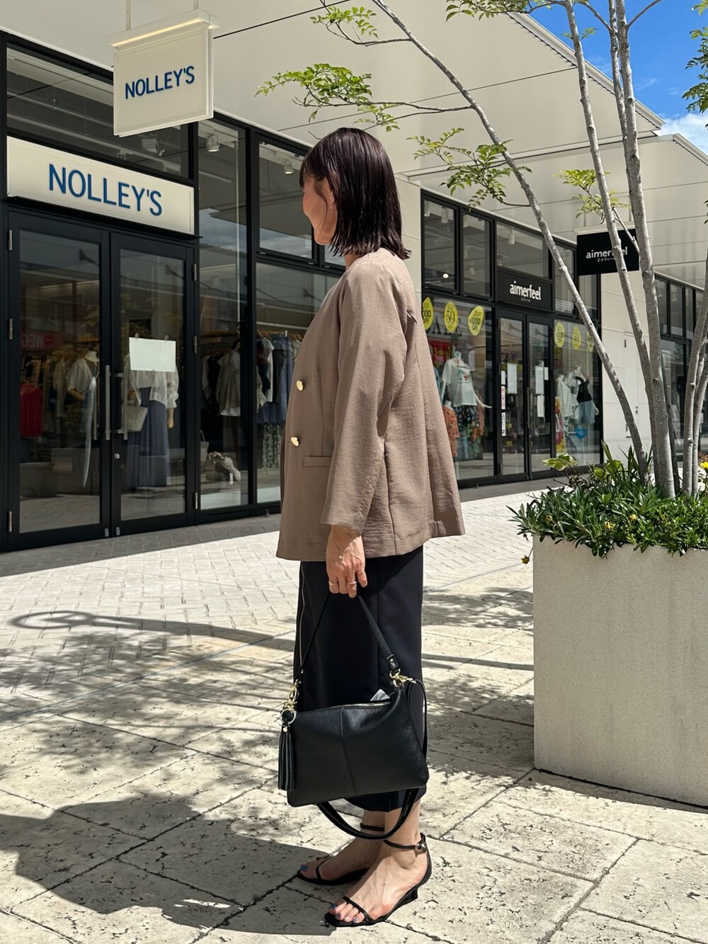 ブルー系のスカート、イエロー系のノーカラージャケット、ベージュ系のシャツ/ブラウスを着用したレディースの夏コーディネートの5枚目の写真