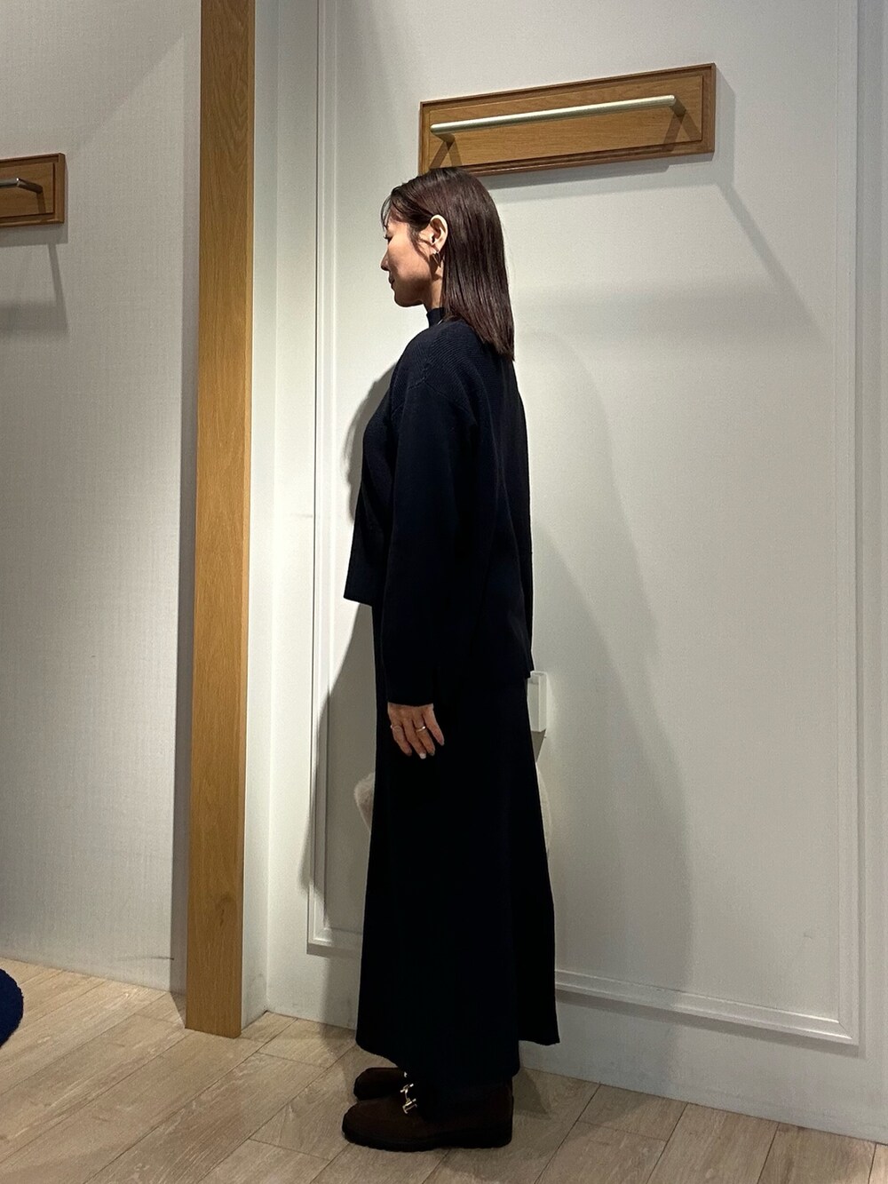 ホワイト系のトートバッグ、ブラウン系のローファー、ブルー系のニット/セーターを着用したレディースの冬コーディネートの2枚目の写真