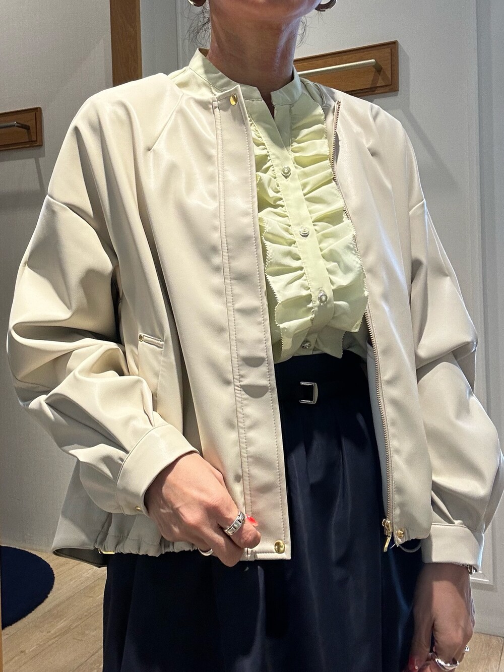 イエロー系のシャツ/ブラウス、ホワイト系のブルゾン、ブルー系のスカートを着用したレディースの冬コーディネートの5枚目の写真