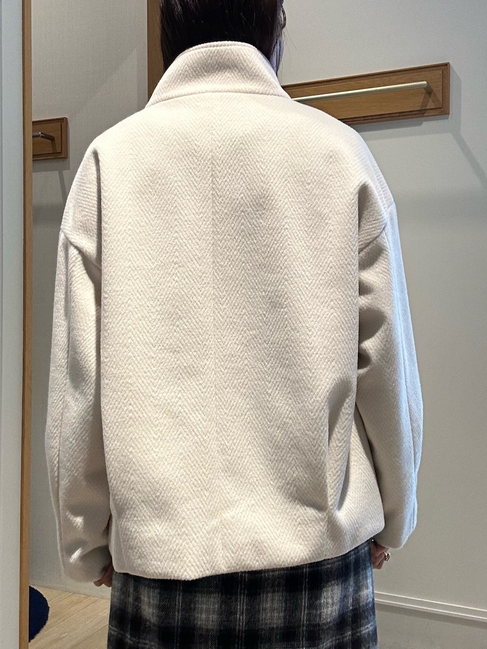 ホワイト系のトートバッグ、ホワイト系のテーラードジャケット、ブラック系のニット/セーターを着用したレディースの冬コーディネートの6枚目の写真