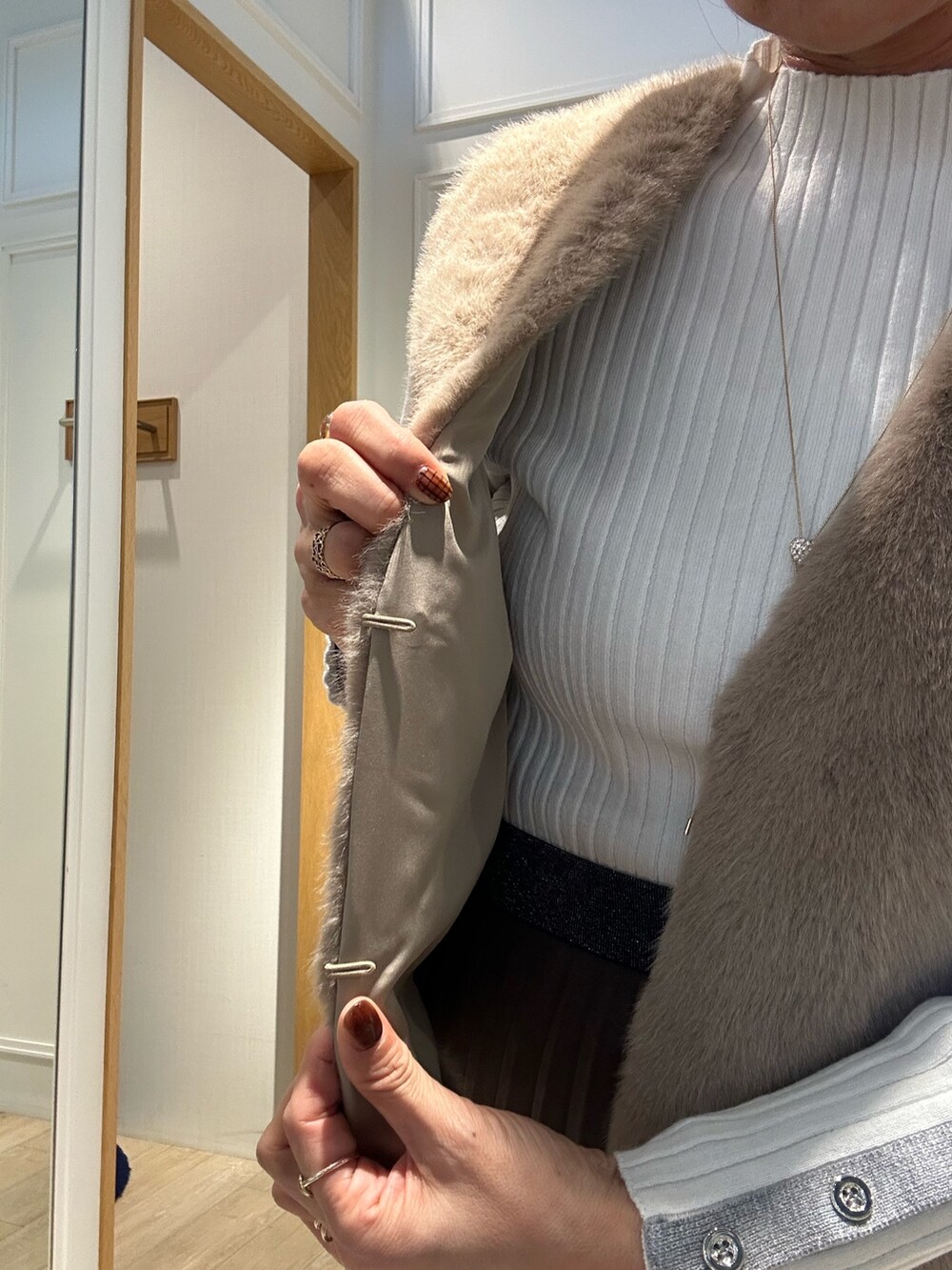 ホワイト系のニット/セーター、ブラウン系のスカート、ブラウン系のブルゾンを着用したレディースの秋コーディネートの5枚目の写真