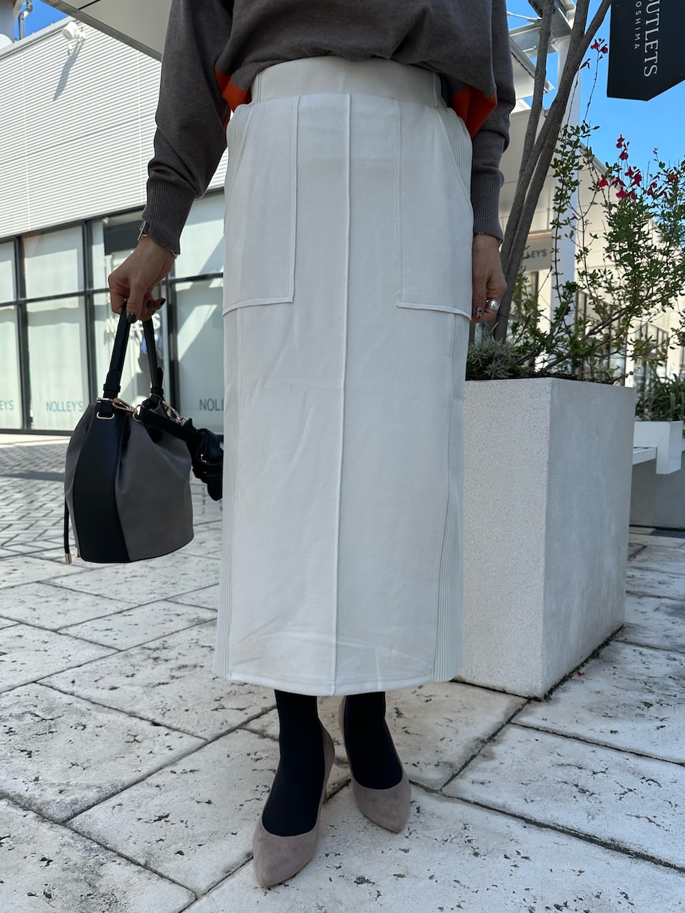 ブラウン系のニット/セーター、グレー系のスカート、ブラウン系のブルゾンを着用したレディースの秋コーディネートの8枚目の写真