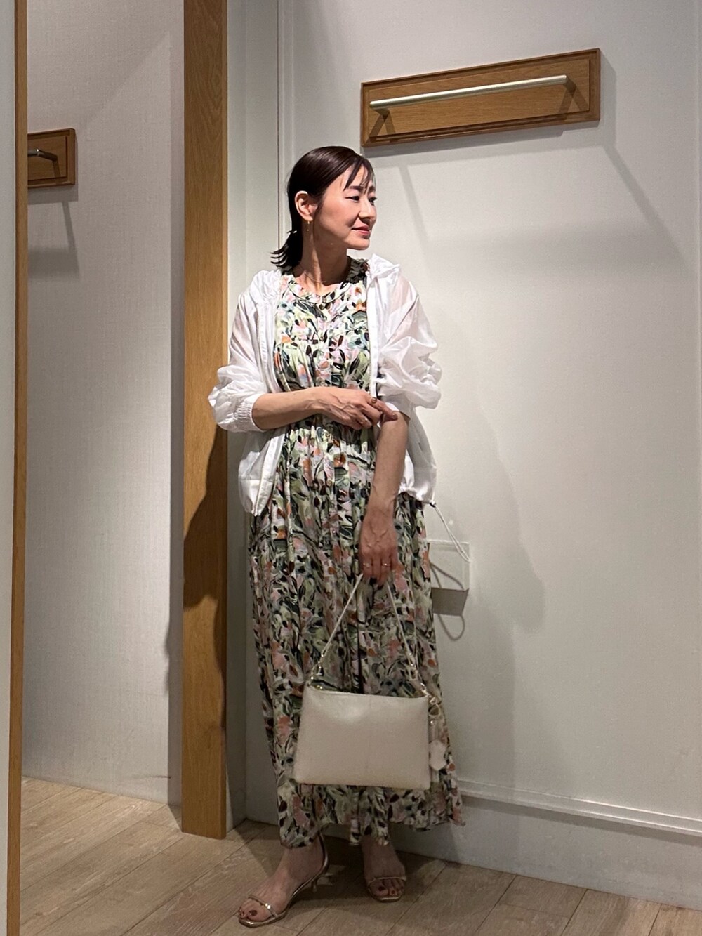 ホワイト系のブルゾン、グリーン系のワンピースを着用したレディースの夏コーディネートの4枚目の写真