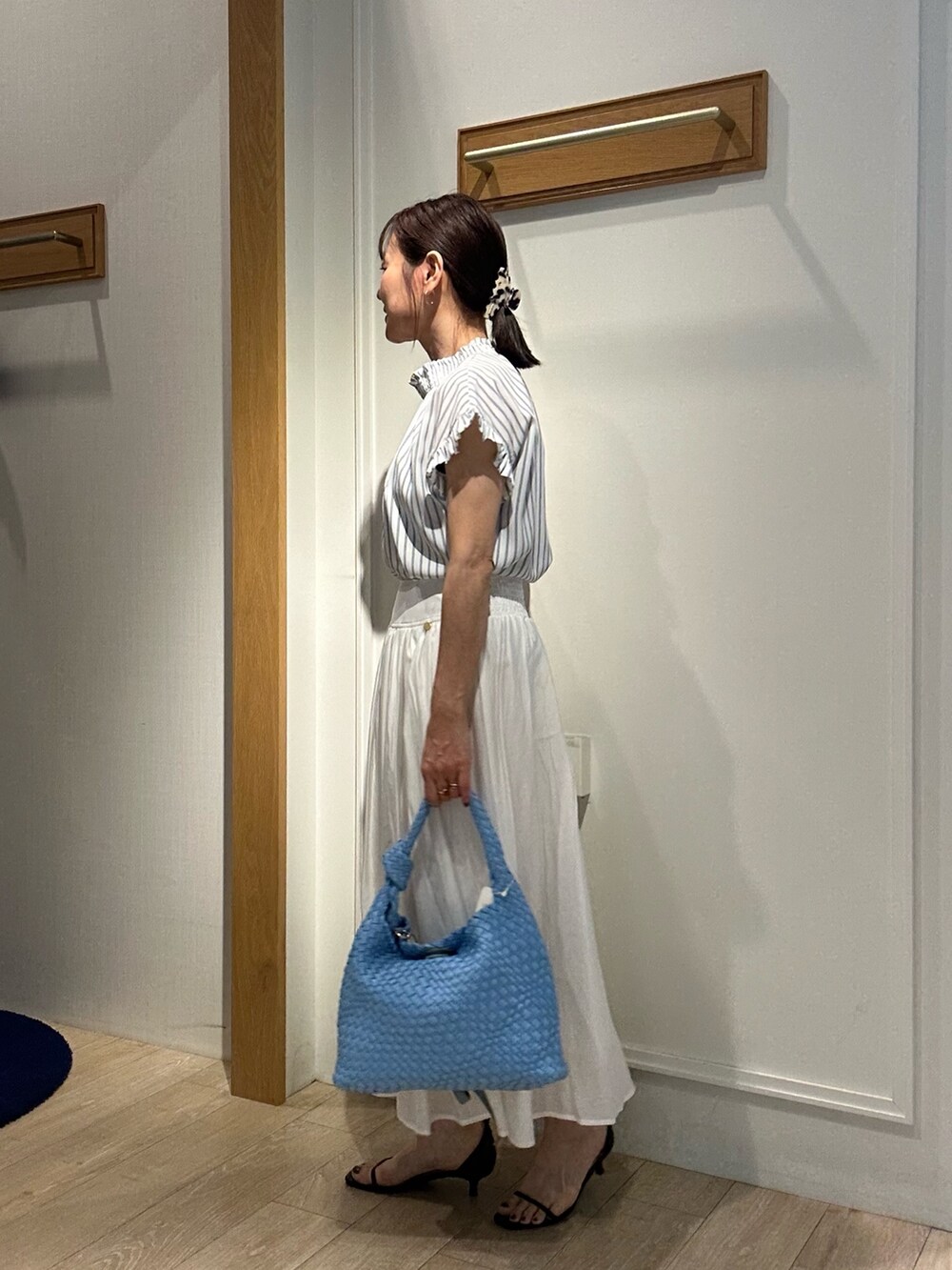 ホワイト系のシャツ/ブラウス、ホワイト系のスカート、ブルー系のショルダーバッグを着用したレディースの春コーディネートの3枚目の写真