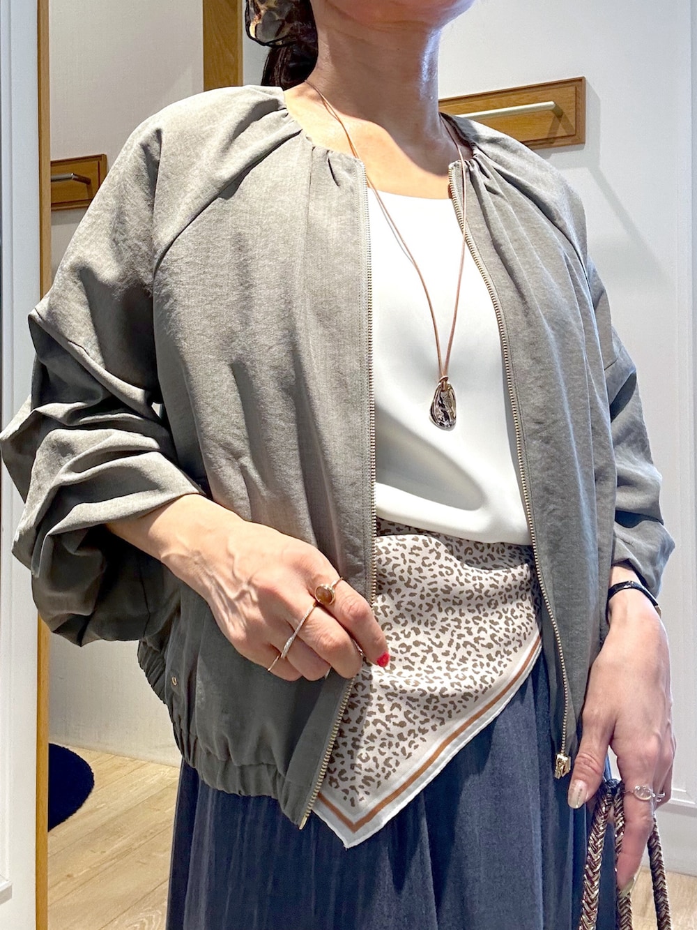 ホワイト系のTシャツ/カットソー、ブラック系のブルゾン、ブルー系のスカートを着用したレディースの春コーディネートの7枚目の写真