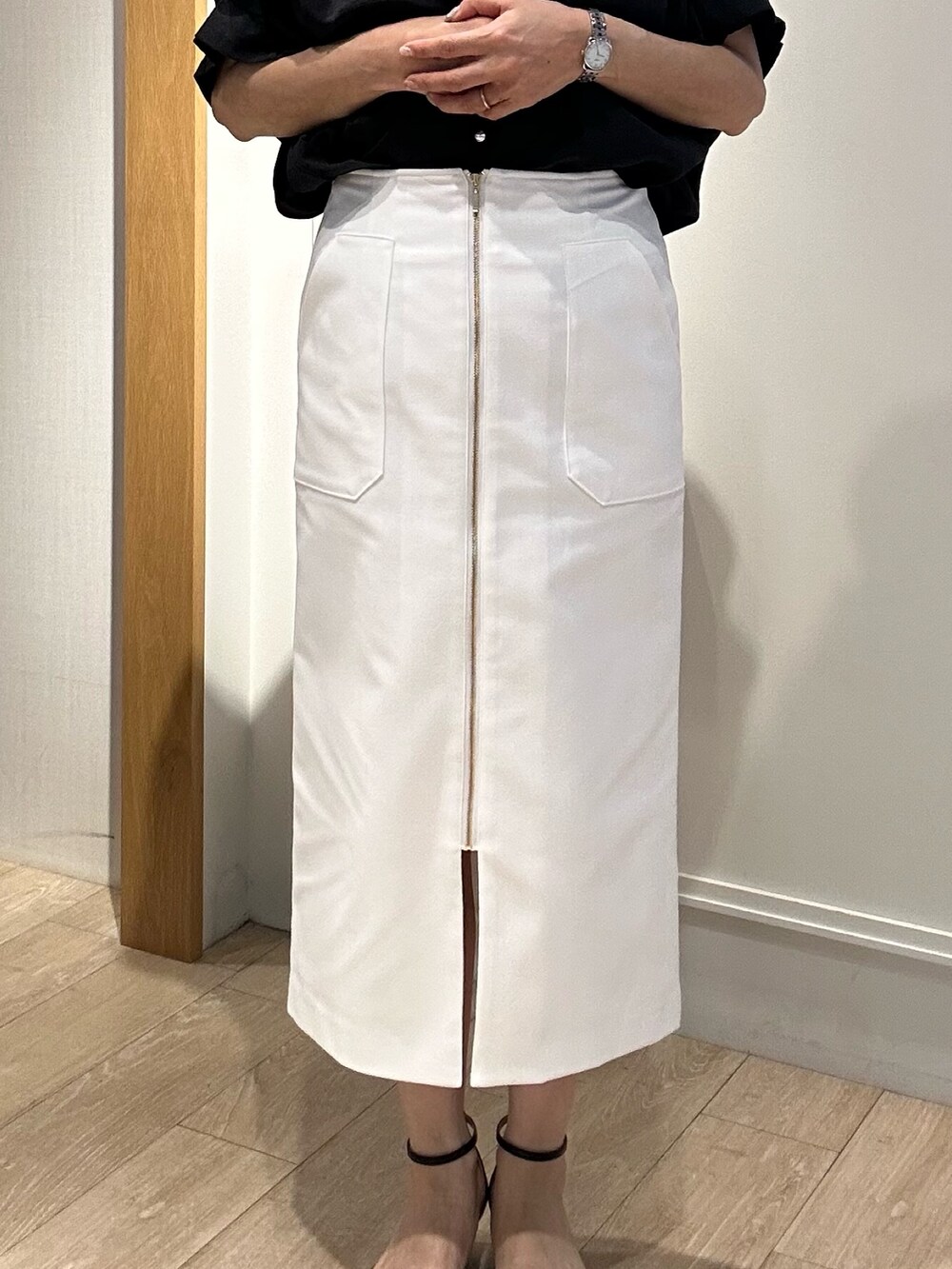 ブラック系のサンダル、グレー系のTシャツ/カットソー、ホワイト系のスカートを着用したレディースの夏コーディネートの8枚目の写真