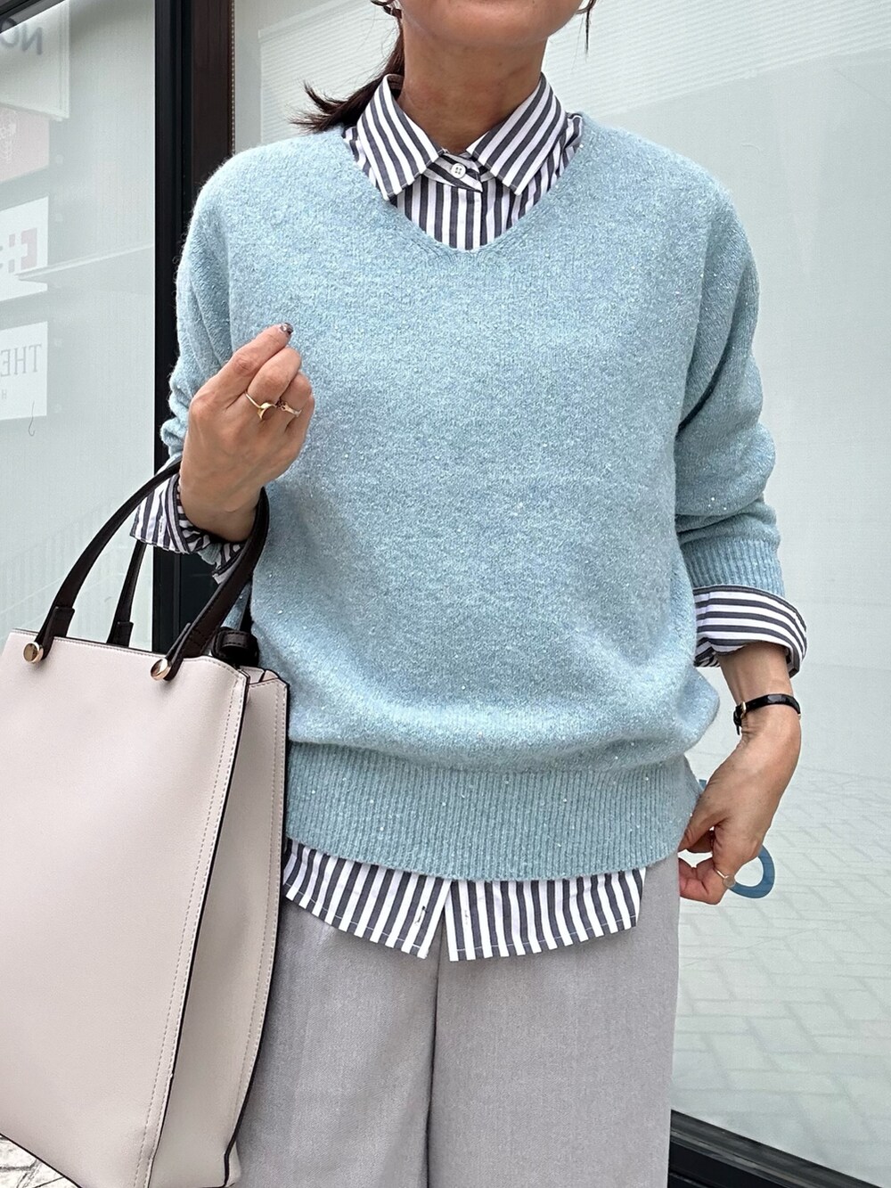 ブルー系のニット/セーター、グレー系のその他パンツ、ブラック系のシャツ/ブラウスを着用したレディースの秋コーディネートの5枚目の写真