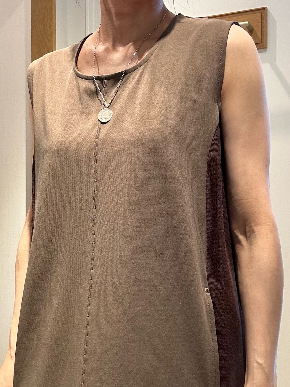 ブラウン系のワンピース、ブラック系のサンダル、ベージュ系のテーラードジャケットを着用したレディースの夏コーディネートの6枚目の写真