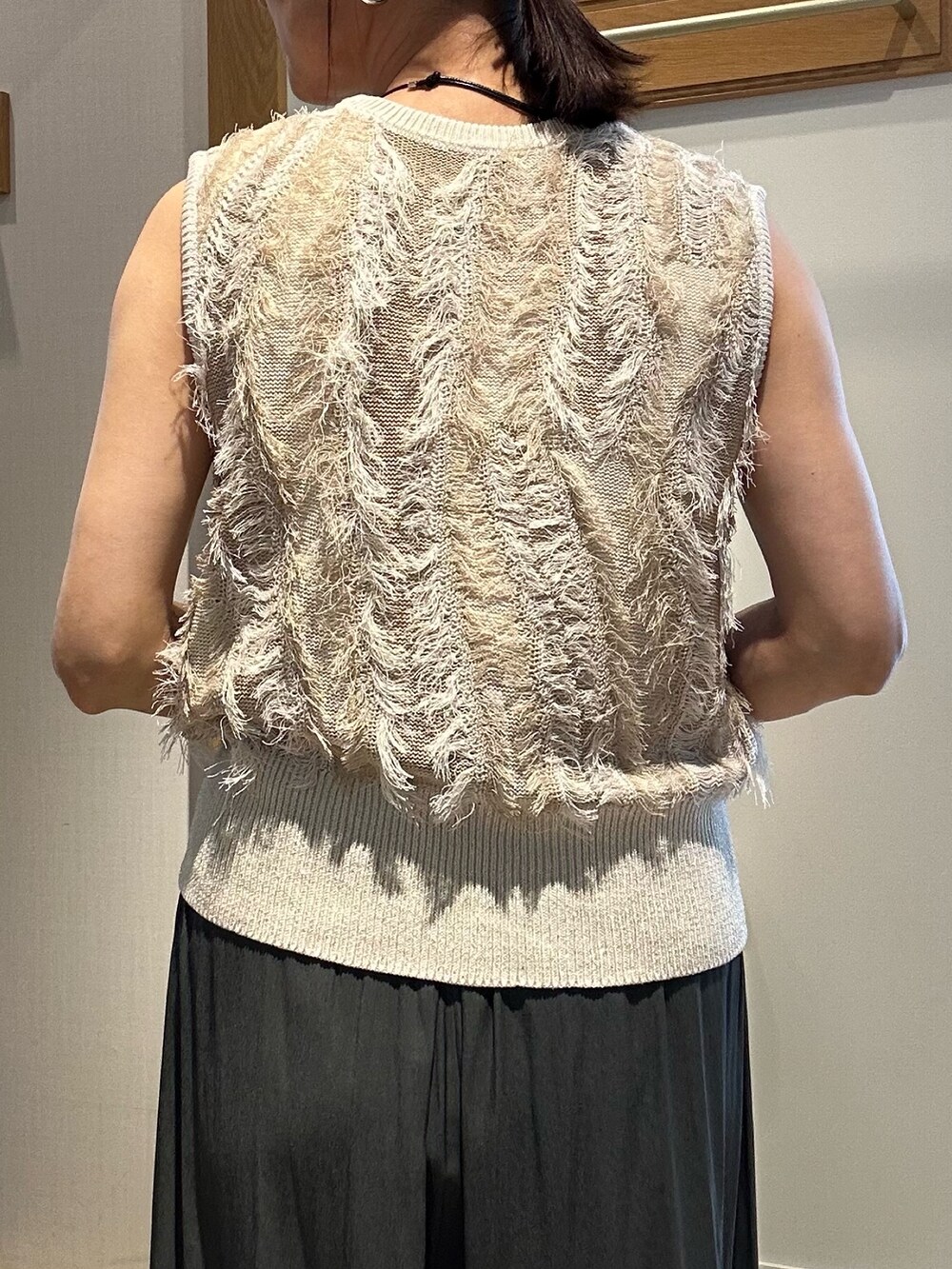 ベージュ系のニット/セーター、グレー系のその他パンツ、グレー系のショルダーバッグを着用したレディースの夏コーディネートの9枚目の写真