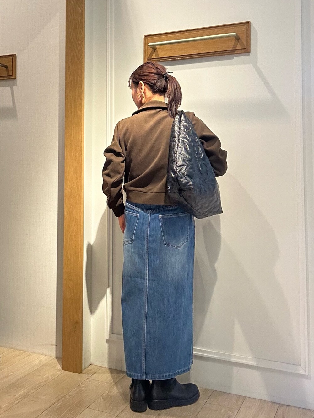 ブラック系のトートバッグ、ホワイト系のブルゾン、ブラウン系のTシャツ/カットソーを着用したレディースの秋コーディネートの4枚目の写真