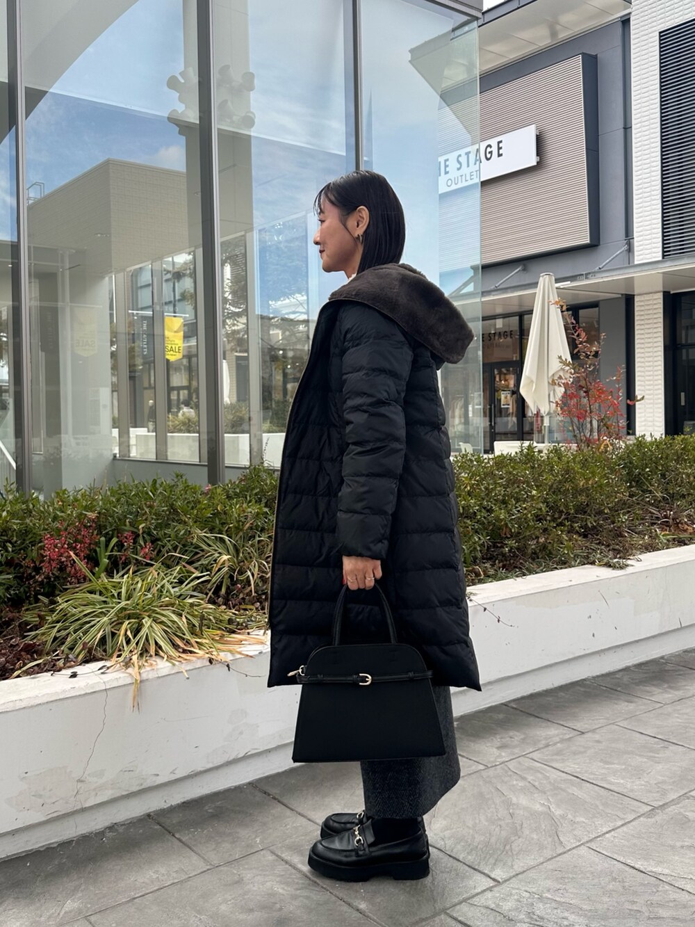 ブルー系のカーディガン/ボレロ、グレー系のスカート、ブラック系のトートバッグを着用したレディースの冬コーディネートの8枚目の写真