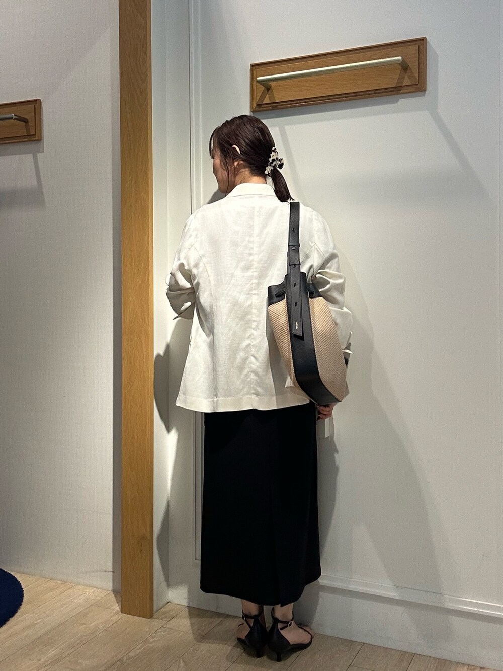 ホワイト系のテーラードジャケット、ベージュ系のシャツ/ブラウス、ブラック系のスカートを着用したレディースの夏コーディネートの3枚目の写真
