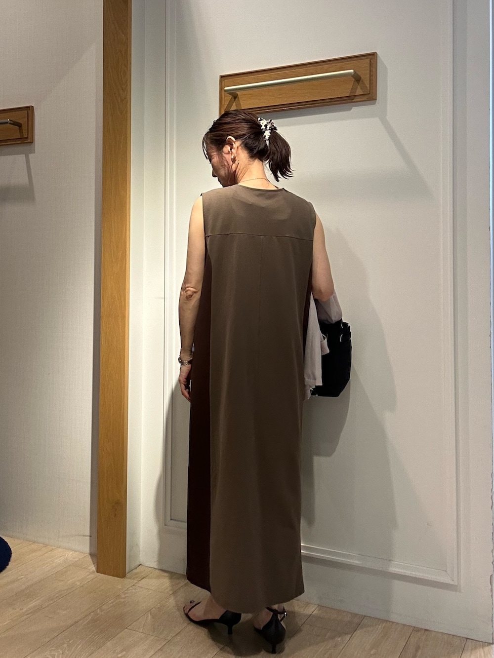 ブラウン系のワンピース、ブラック系のサンダル、ベージュ系のテーラードジャケットを着用したレディースの夏コーディネートの4枚目の写真