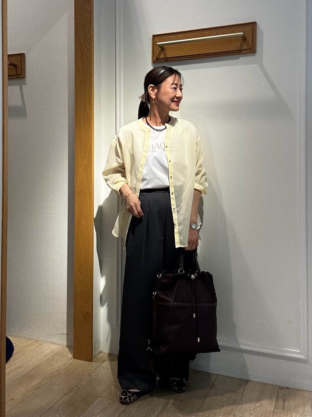 イエロー系のシャツ/ブラウス、グレー系のその他パンツ、ブラック系のネックレスを着用したレディースの夏コーディネートの4枚目の写真