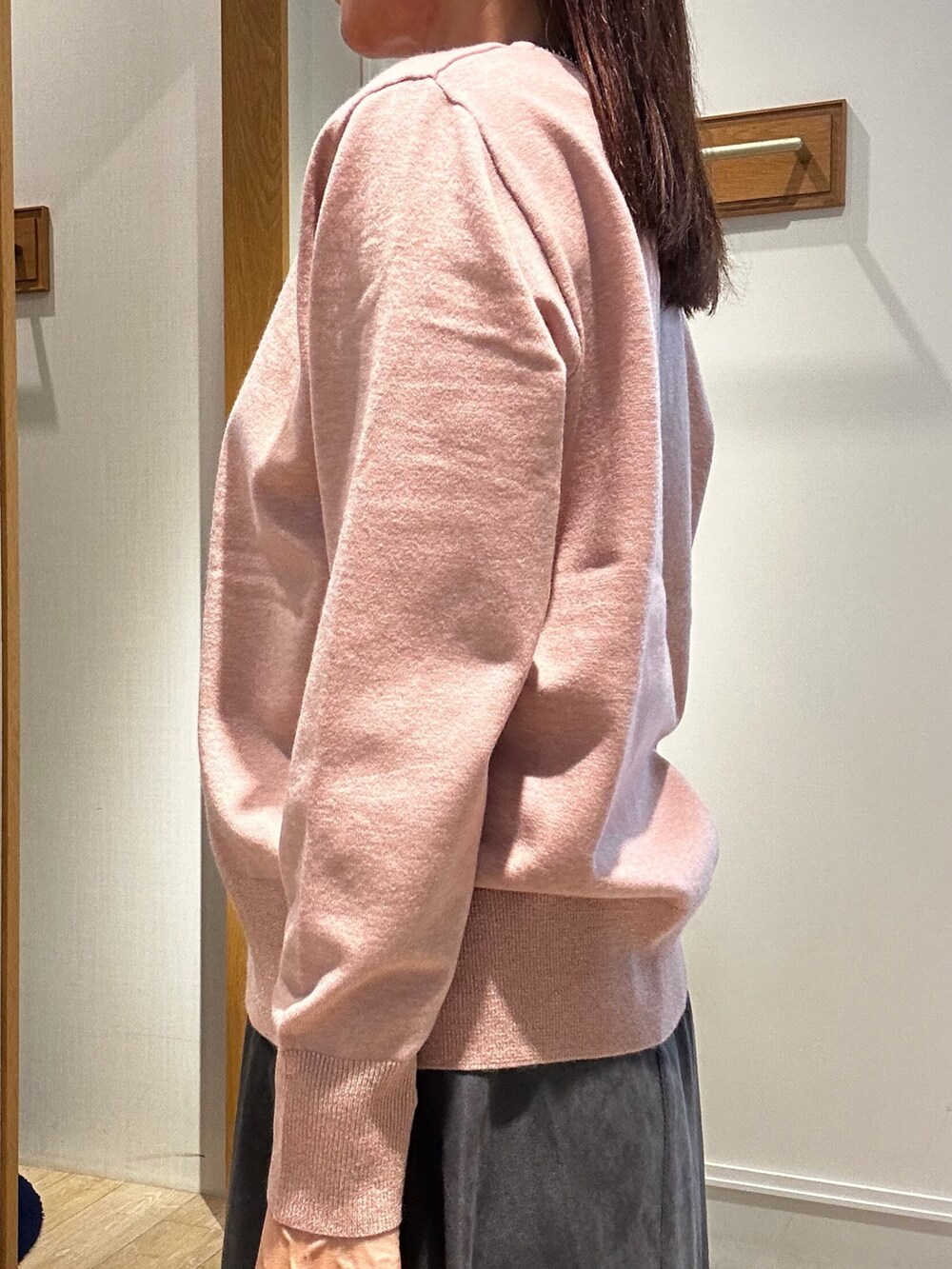 ピンク系のニット/セーター、グレー系のスカート、ブルー系のショルダーバッグを着用したレディースの秋コーディネートの5枚目の写真