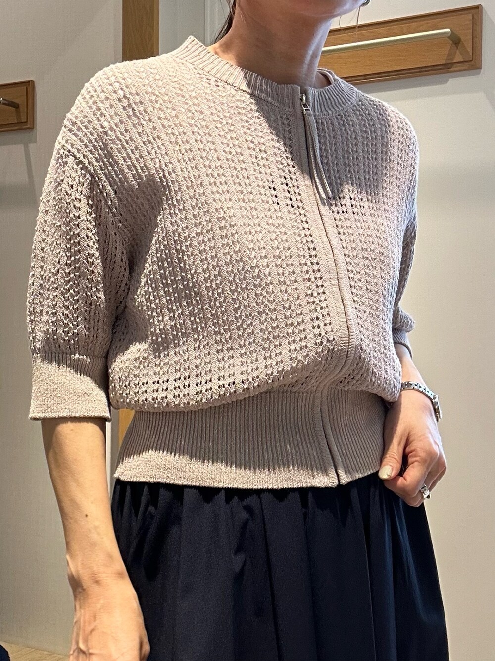 ベージュ系のニット/セーター、ホワイト系のTシャツ/カットソー、ブルー系のスカートを着用したレディースの春コーディネートの7枚目の写真