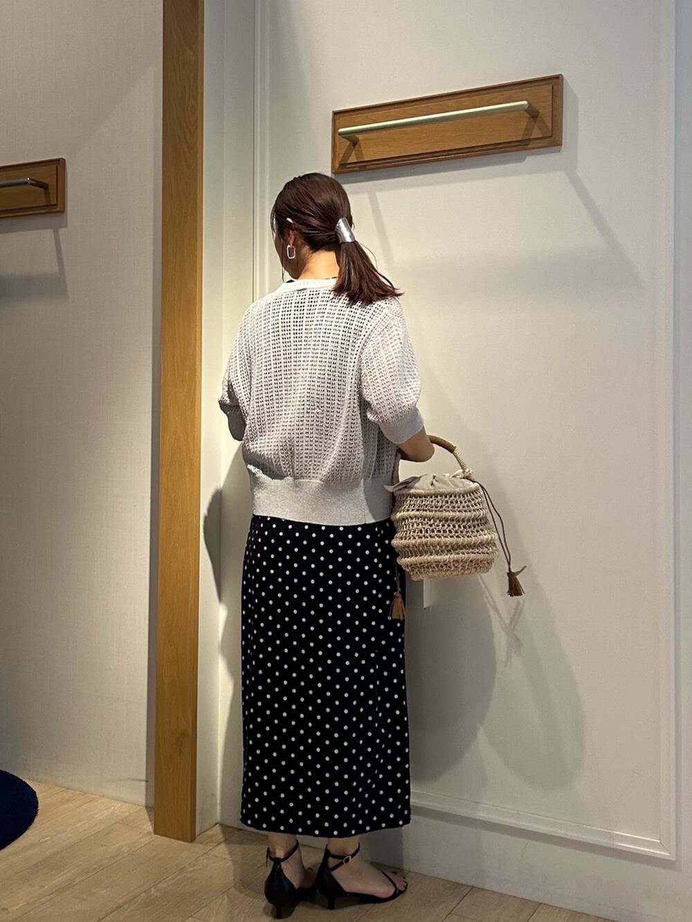 グレー系のニット/セーター、ブラック系のワンピース、ブラック系のサンダルを着用したレディースの春コーディネートの3枚目の写真