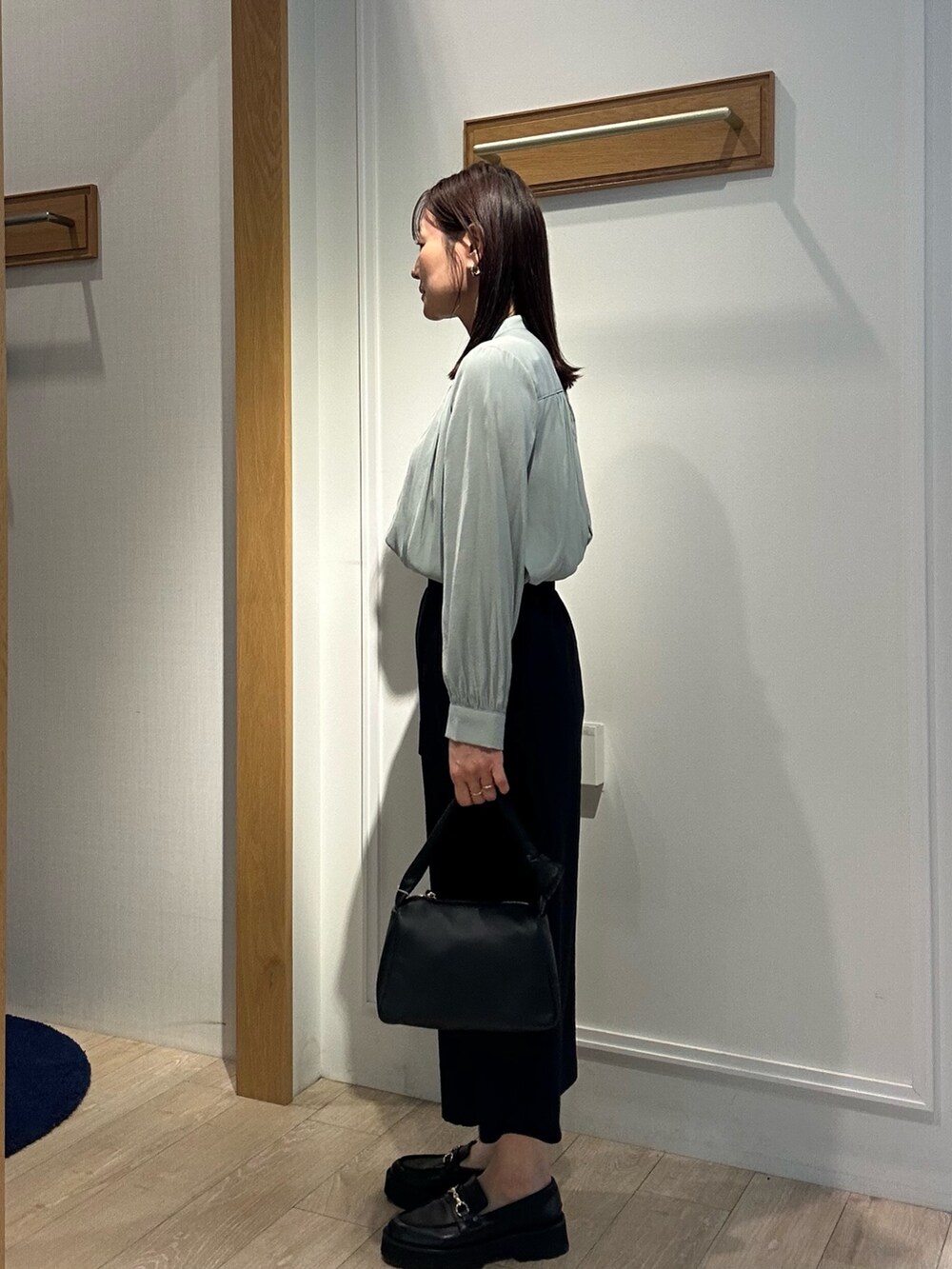 グリーン系のシャツ/ブラウス、ブラック系のスカート、ブラック系のショルダーバッグを着用したレディースの春コーディネートの2枚目の写真