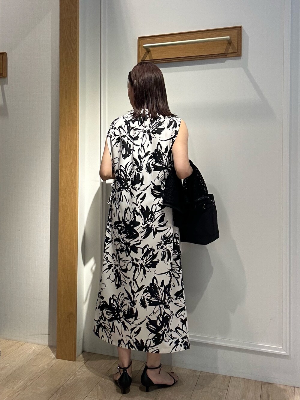 ホワイト系のワンピース、ブラック系のトートバッグを着用したレディースの秋コーディネートの2枚目の写真