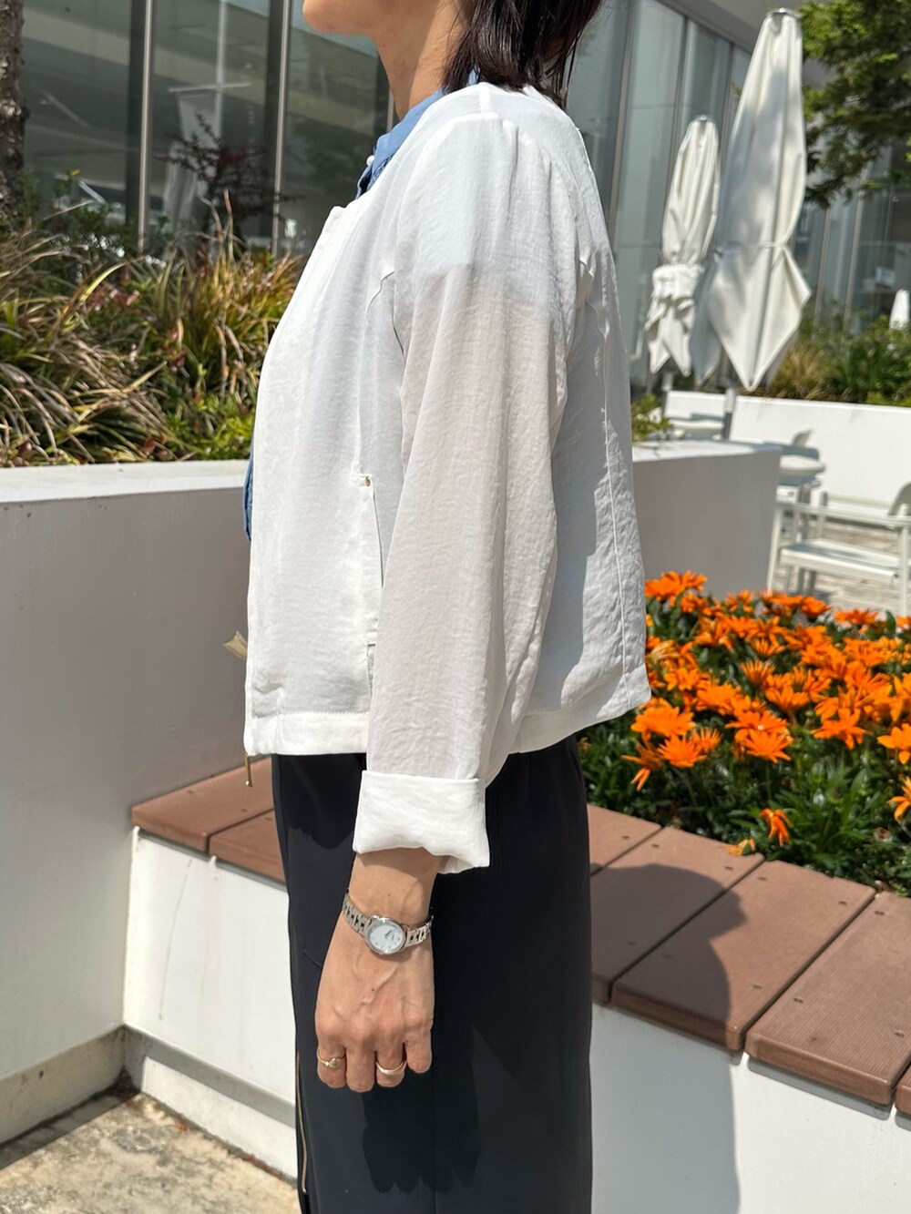 ホワイト系のブルゾン、グレー系のTシャツ/カットソー、グリーン系のスカートを着用したレディースの春コーディネートの7枚目の写真