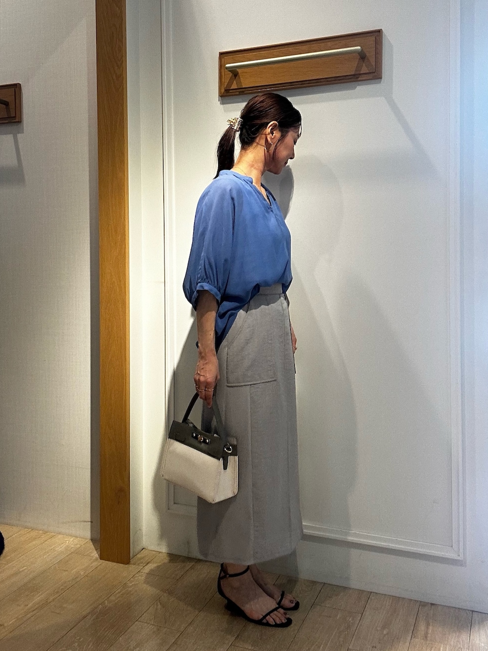 ブルー系のシャツ/ブラウス、ホワイト系のTシャツ/カットソー、グレー系のスカートを着用したレディースの夏コーディネートの2枚目の写真