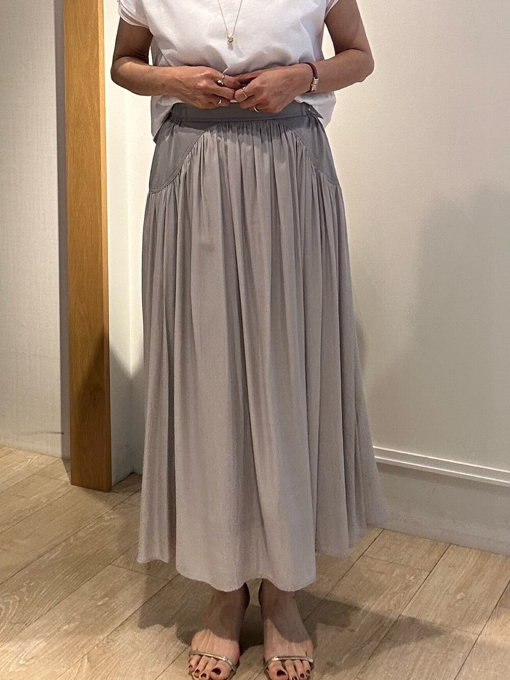 ベージュ系のスカート、ホワイト系のブルゾン、ホワイト系のTシャツ/カットソーを着用したレディースの春コーディネートの8枚目の写真