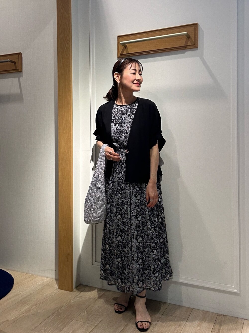 ブラック系のワンピース、ブラック系のノーカラージャケット、ブラック系のサンダルを着用したレディースの夏コーディネートの5枚目の写真