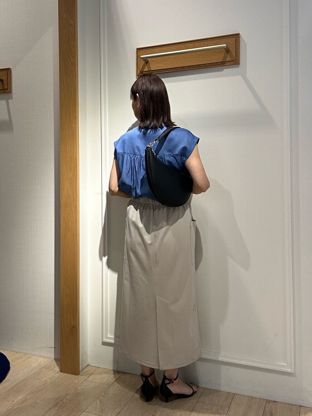 ブルー系のシャツ/ブラウス、ベージュ系のスカート、ブラック系のサンダルを着用したレディースの夏コーディネートの3枚目の写真