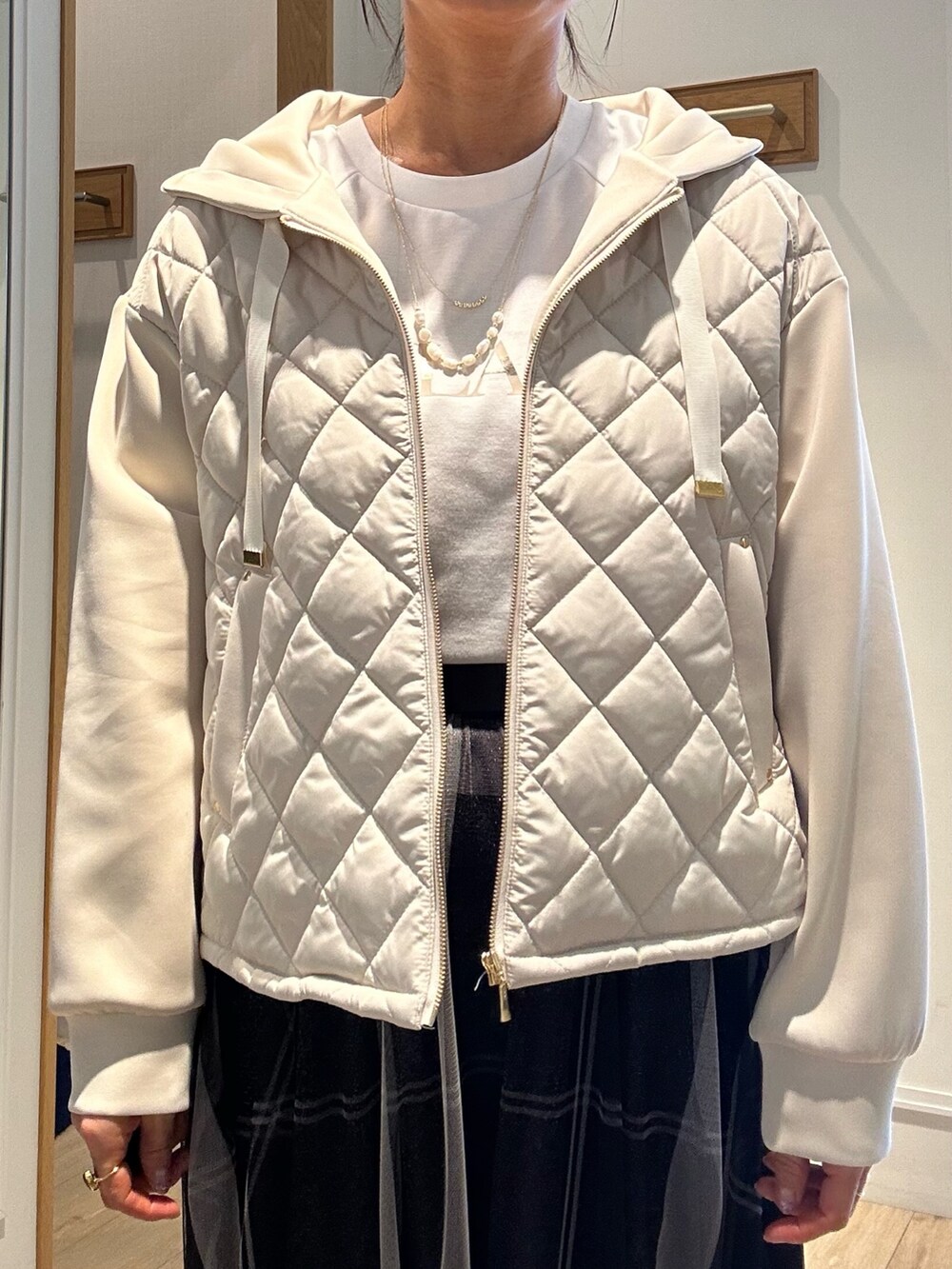 ホワイト系のTシャツ/カットソー、グレー系のスカート、ベージュ系のブルゾンを着用したレディースの冬コーディネートの7枚目の写真