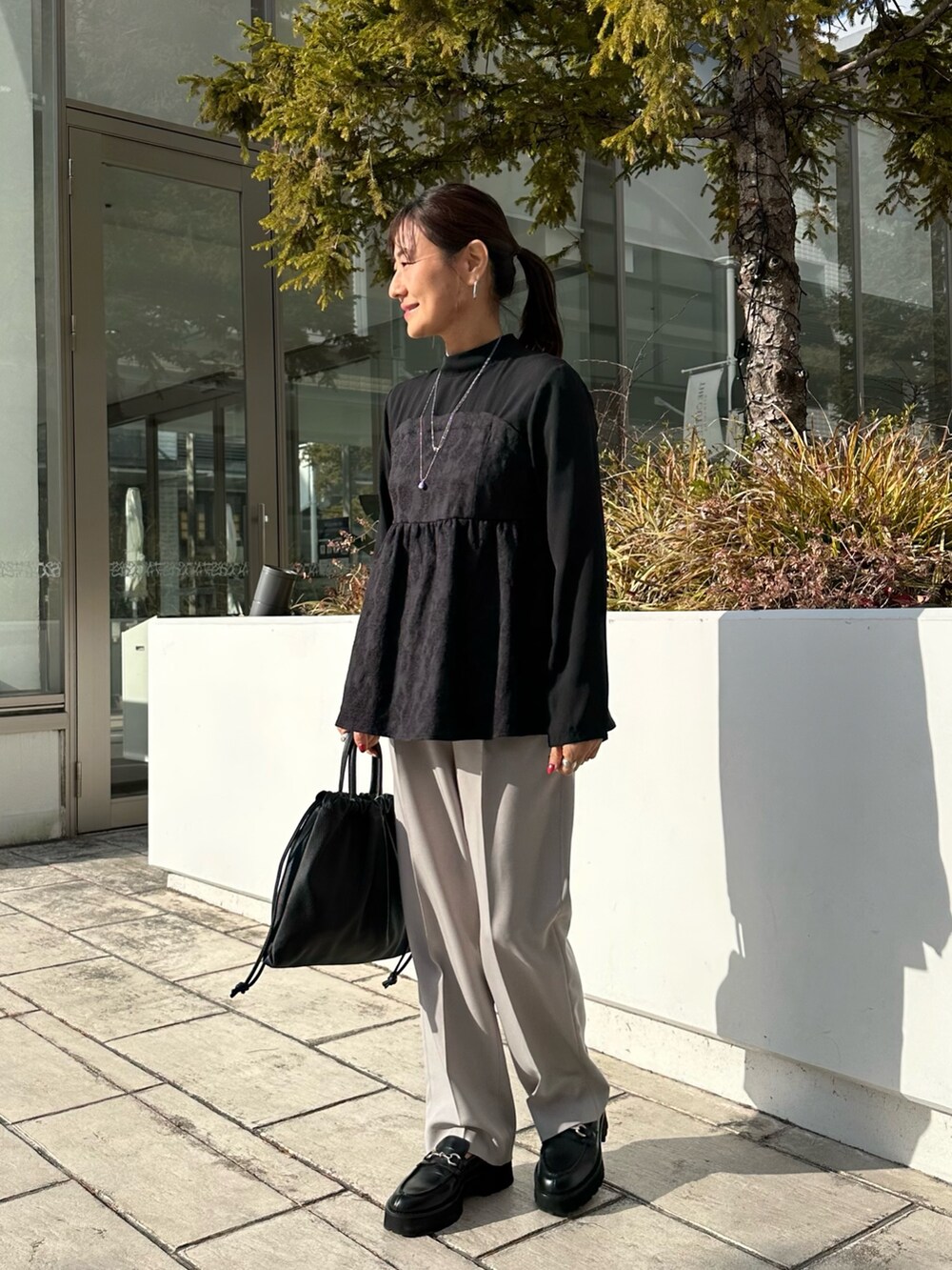 ブラック系のシャツ/ブラウス、ベージュ系のその他パンツ、ブラック系のショルダーバッグを着用したレディースの冬コーディネートの2枚目の写真
