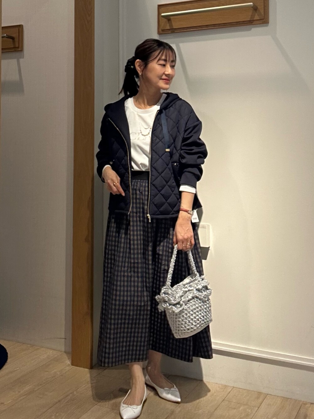 ホワイト系のTシャツ/カットソー、ブルー系のブルゾン、ブラウン系のスカートを着用したレディースの冬コーディネートの2枚目の写真
