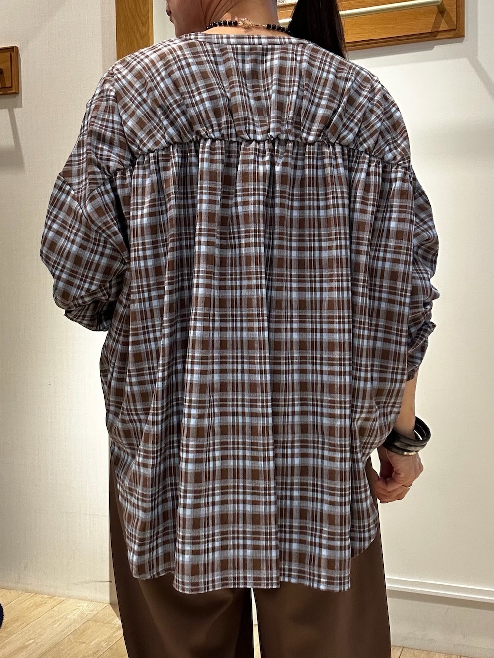 ブラウン系のシャツ/ブラウス、ブラウン系のその他パンツ、ブラック系のネックレスを着用したレディースの秋コーディネートの8枚目の写真