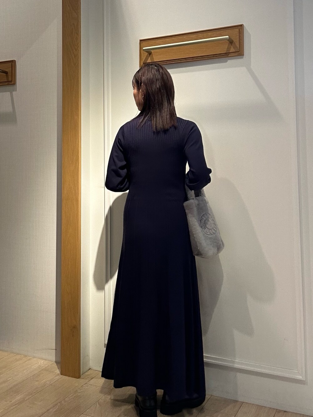 ブルー系のワンピース、グレー系のトートバッグ、ベージュ系のブルゾンを着用したレディースの秋コーディネートの2枚目の写真