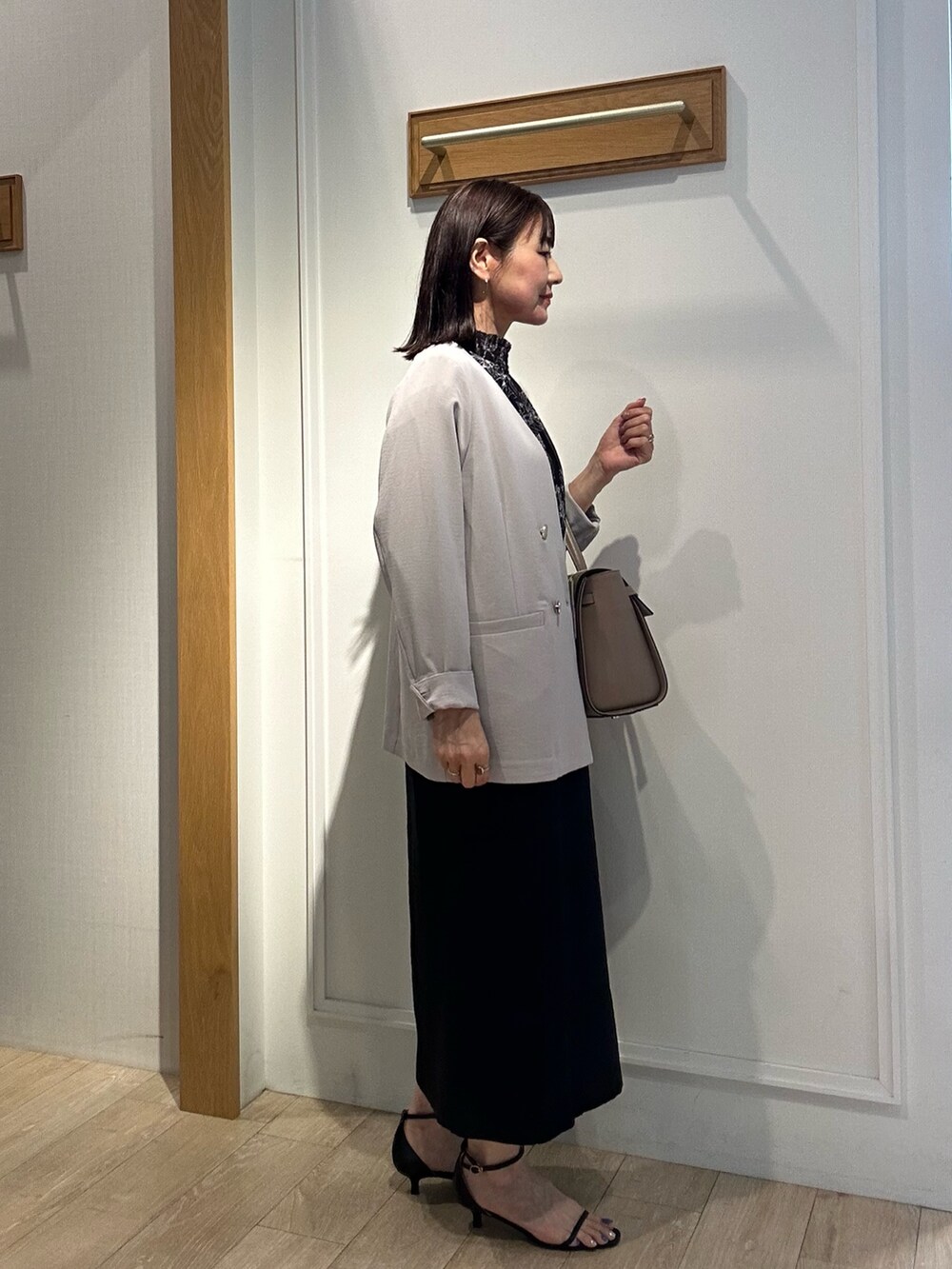 ブラック系のサンダル、ブラック系のシャツ/ブラウス、ベージュ系のノーカラージャケットを着用したレディースの夏コーディネートの2枚目の写真