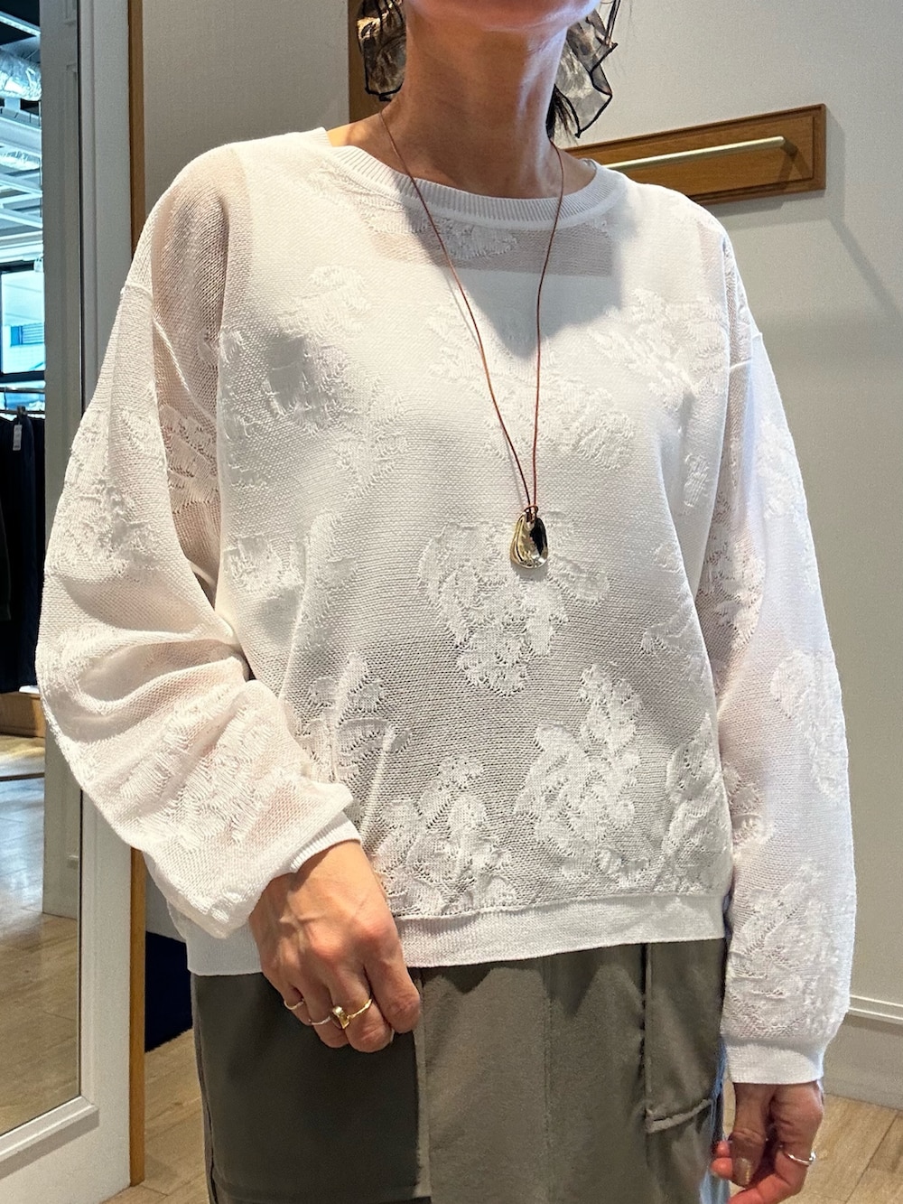 ホワイト系のニット/セーター、ホワイト系のTシャツ/カットソー、グリーン系のスカートを着用したレディースの春コーディネートの5枚目の写真