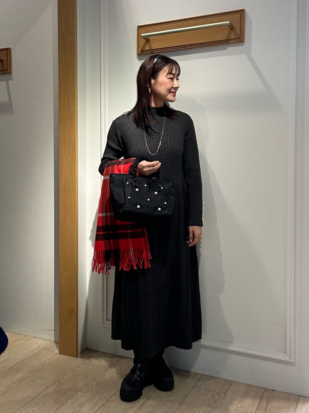 ベージュ系のブルゾン、グレー系のワンピース、ブラック系のダウンジャケット/コートを着用したレディースの冬コーディネートの7枚目の写真