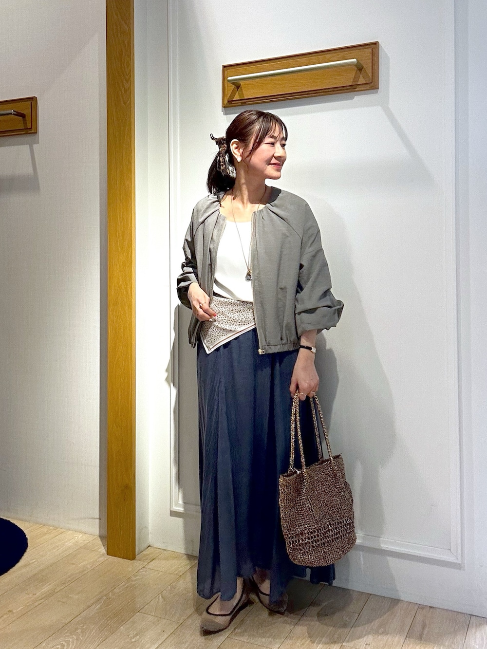 ホワイト系のTシャツ/カットソー、ブラック系のブルゾン、ブルー系のスカートを着用したレディースの春コーディネートの6枚目の写真