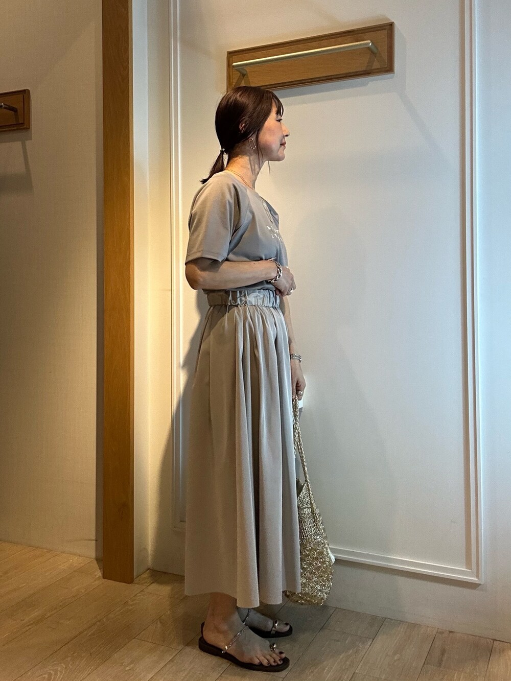 グリーン系のスカート、グレー系のTシャツ/カットソーを着用したレディースの春コーディネートの2枚目の写真