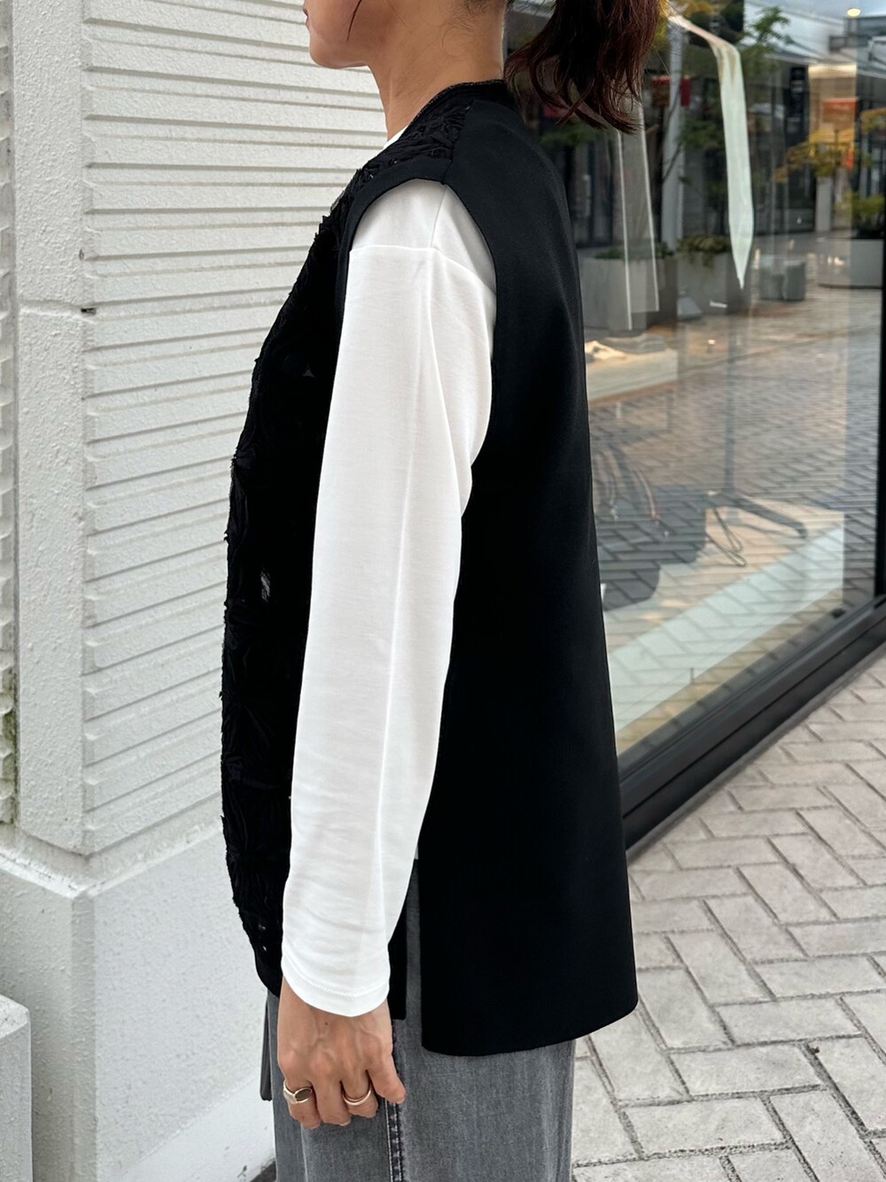 グレー系のデニムパンツ、ブラック系のニット/セーター、グレー系のトートバッグを着用したレディースの秋コーディネートの4枚目の写真