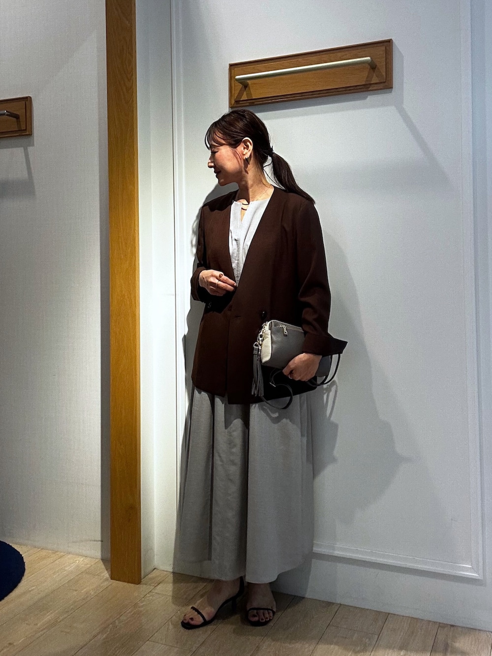 ベージュ系のワンピース、ブルー系のカーディガン/ボレロ、グレー系のショルダーバッグを着用したレディースの春コーディネートの10枚目の写真
