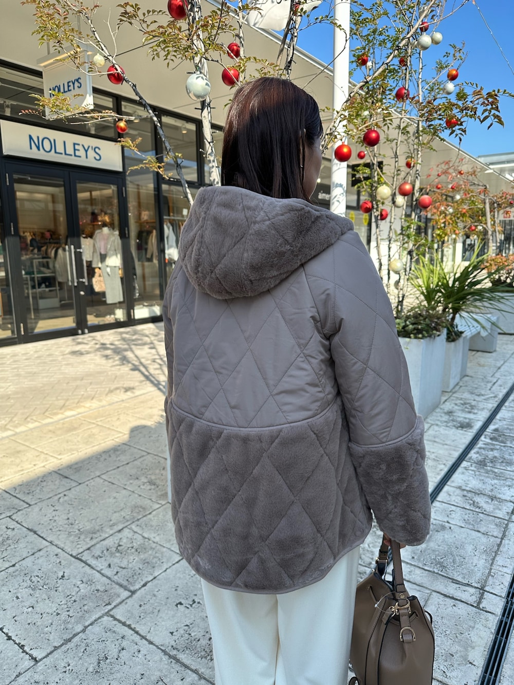 ブラウン系のブルゾン、オレンジ系のニット/セーターを着用したレディースの冬コーディネートの7枚目の写真