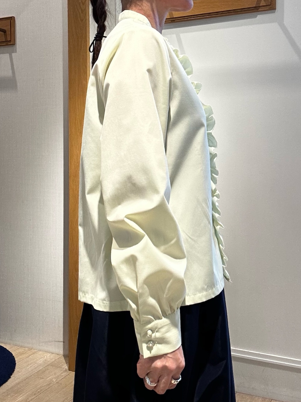 イエロー系のシャツ/ブラウス、ブルー系のスカート、ホワイト系のニット/セーターを着用したレディースの冬コーディネートの4枚目の写真