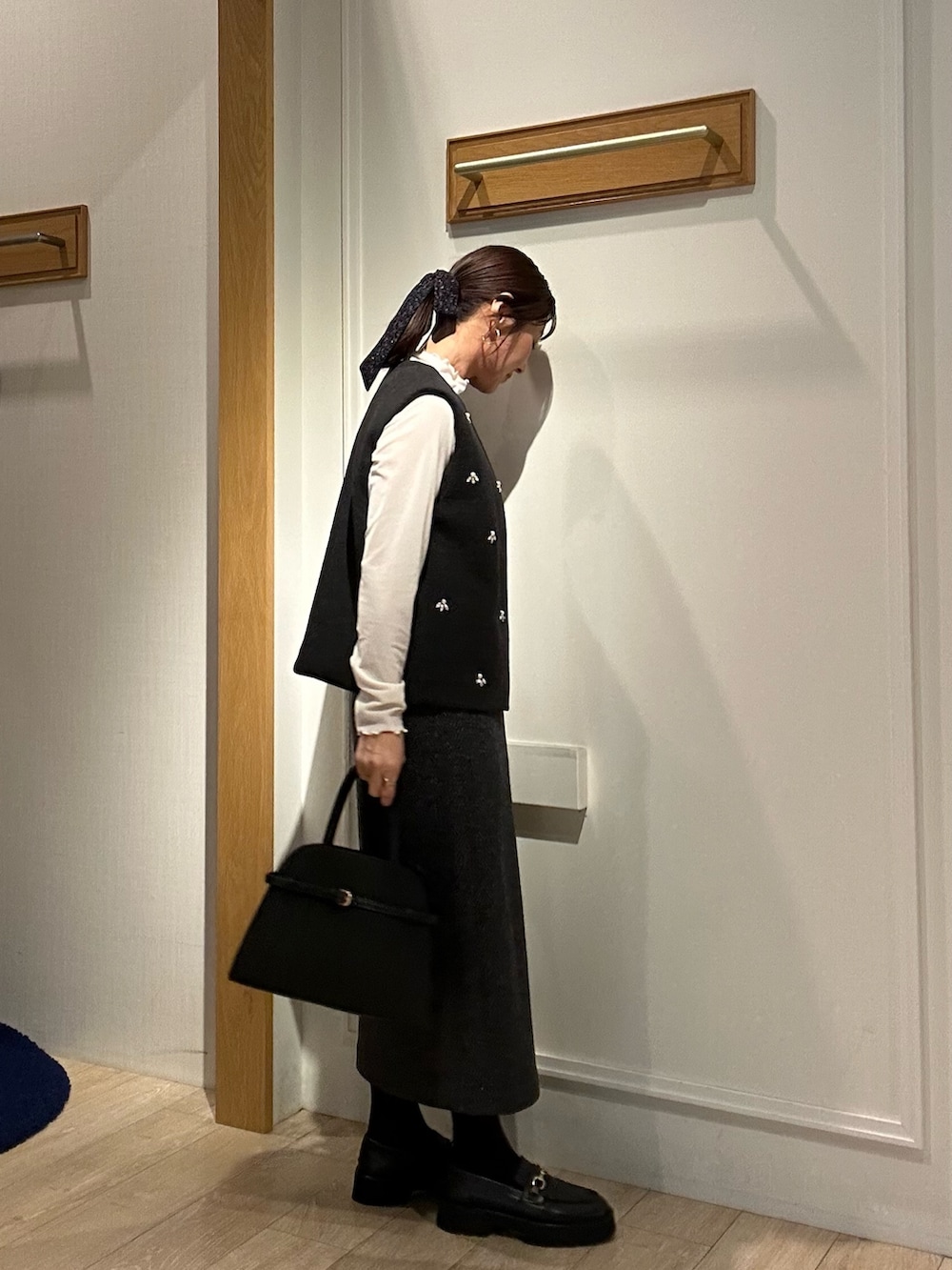 グレー系のブルゾン、ホワイト系のTシャツ/カットソー、グレー系のスカートを着用したレディースの秋コーディネートの4枚目の写真