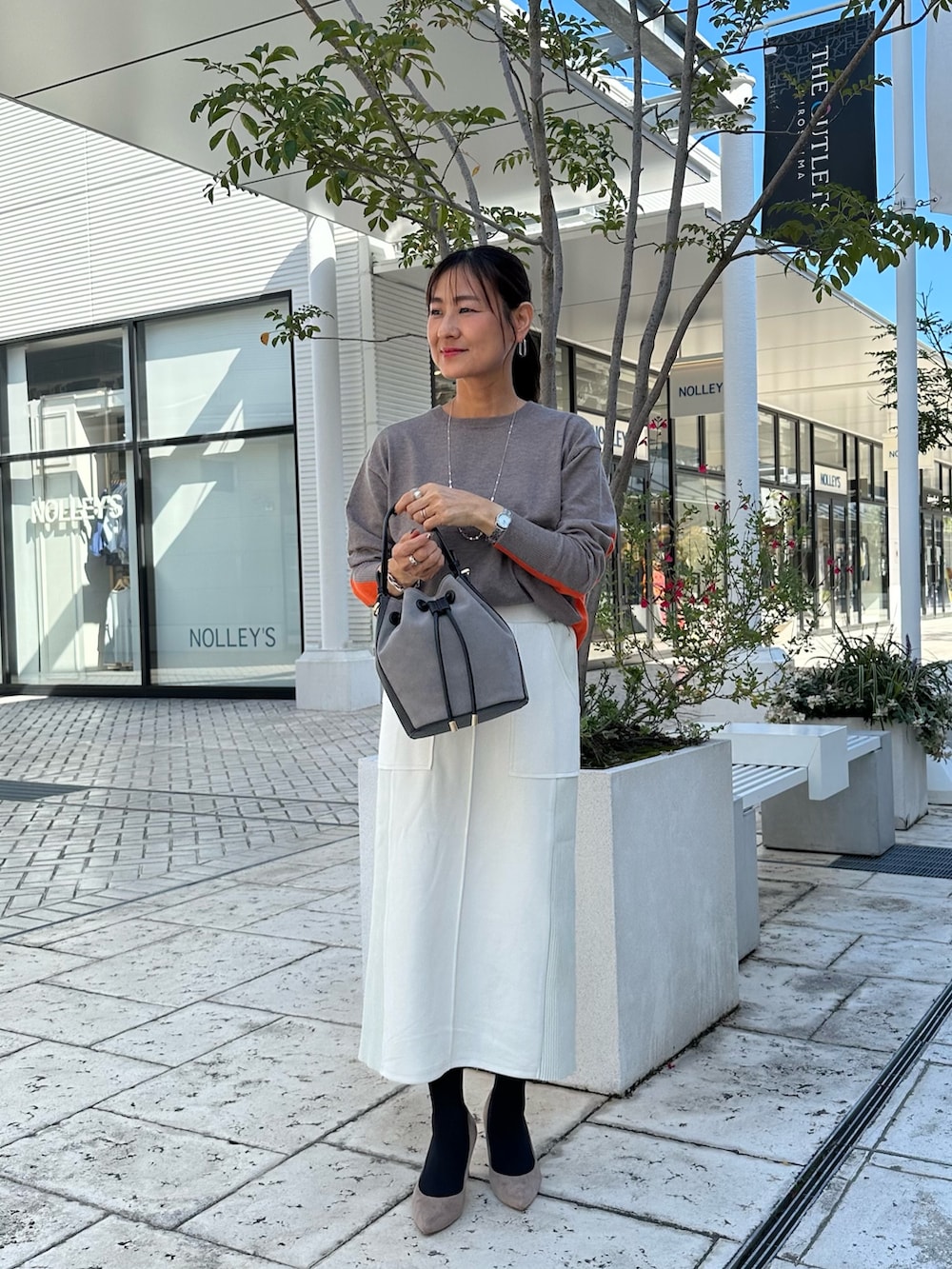 ブラウン系のニット/セーター、グレー系のスカート、ブラウン系のブルゾンを着用したレディースの秋コーディネートの4枚目の写真