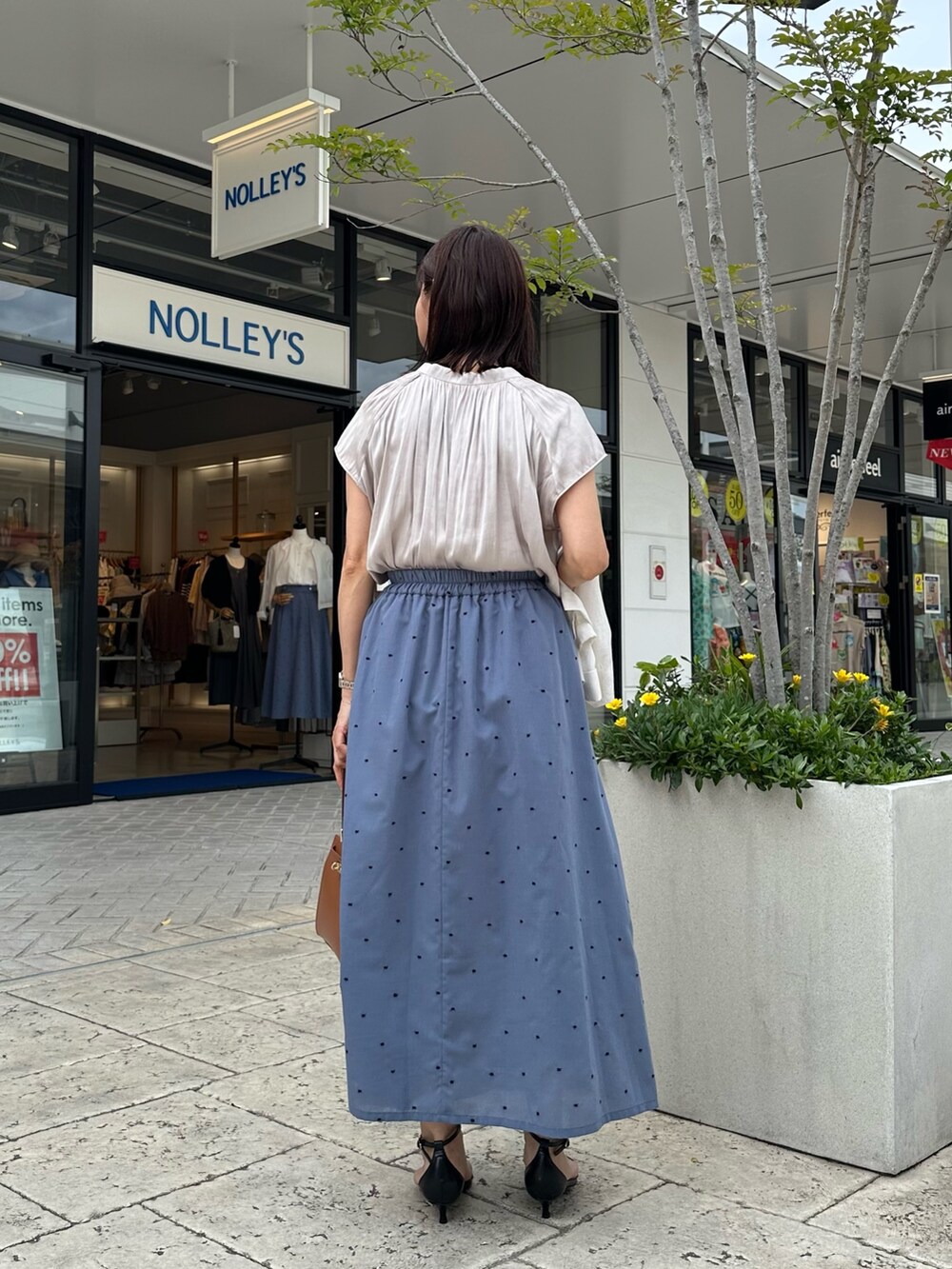 ベージュ系のシャツ/ブラウス、ブルー系のスカート、イエロー系のショルダーバッグを着用したレディースの春コーディネートの2枚目の写真
