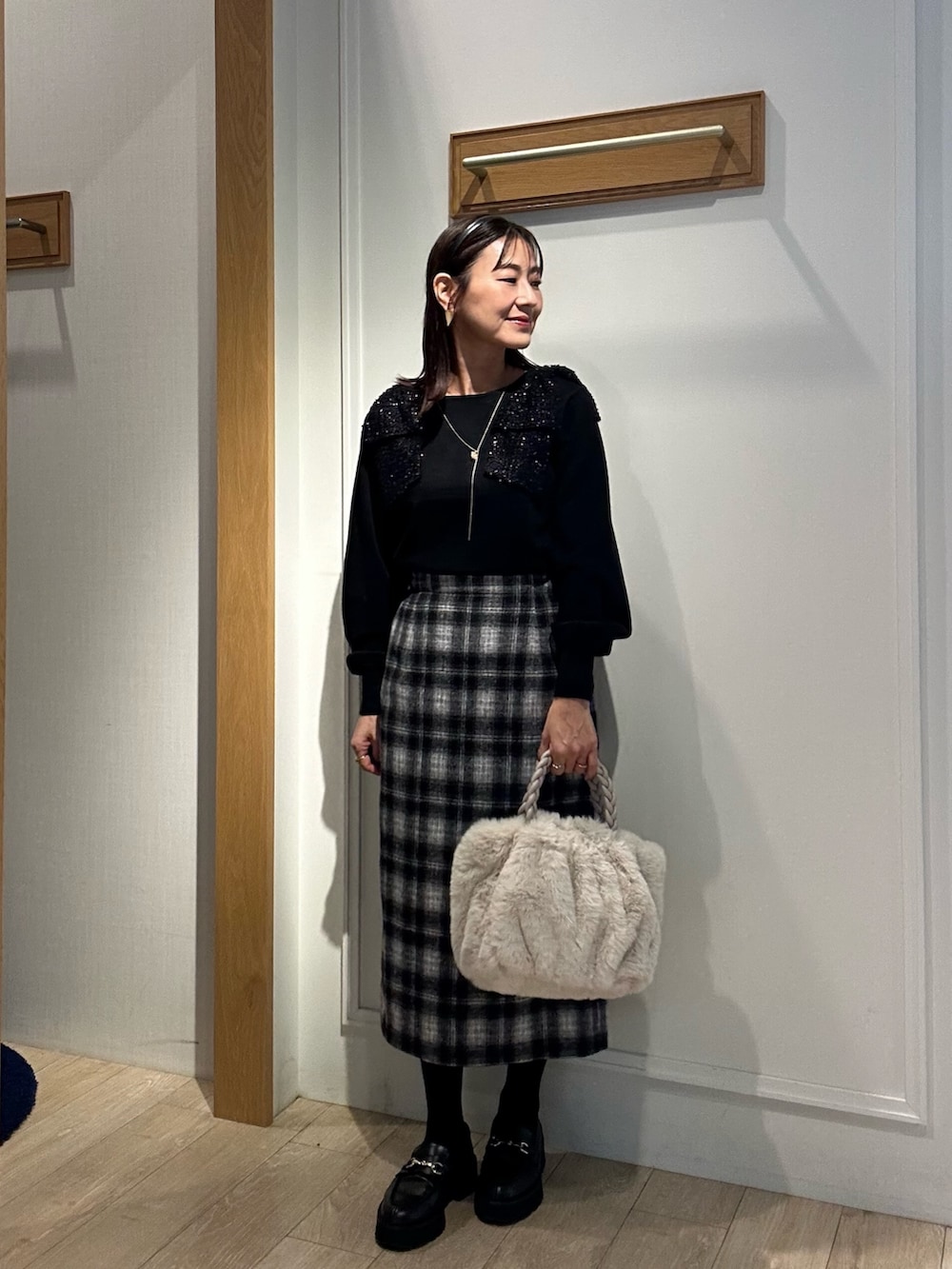 ホワイト系のトートバッグ、ホワイト系のテーラードジャケット、ブラック系のニット/セーターを着用したレディースの冬コーディネートの10枚目の写真