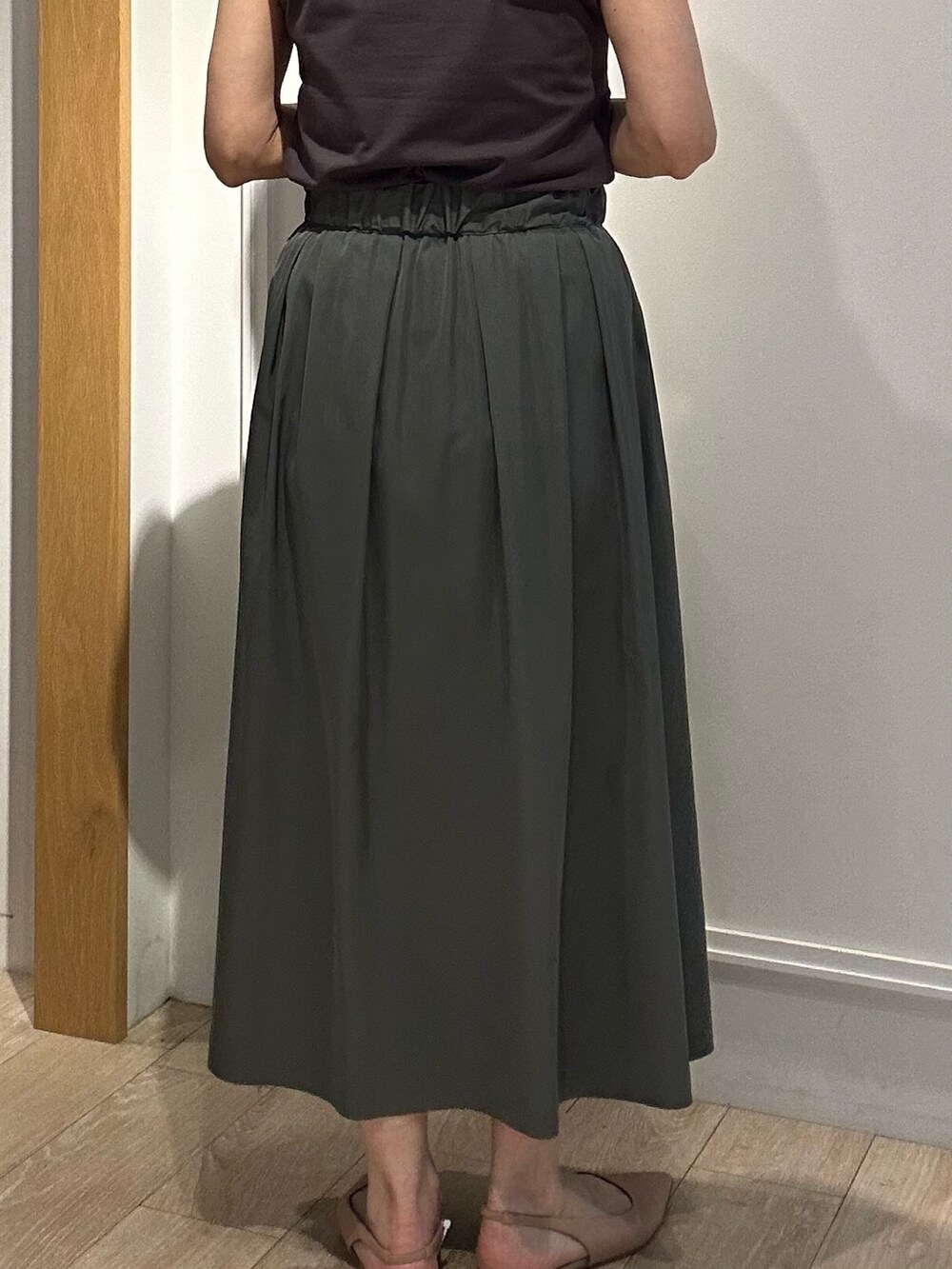 グレー系のTシャツ/カットソー、ホワイト系のテーラードジャケット、ブラック系のスカートを着用したレディースの春コーディネートの6枚目の写真