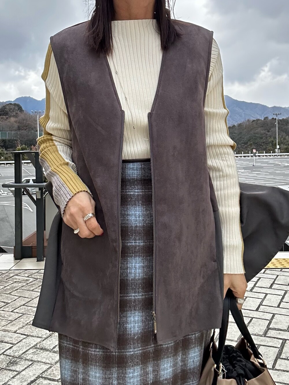グレー系のブルゾン、グレー系のその他パンツ、ホワイト系のニット/セーターを着用したレディースの冬コーディネートの9枚目の写真