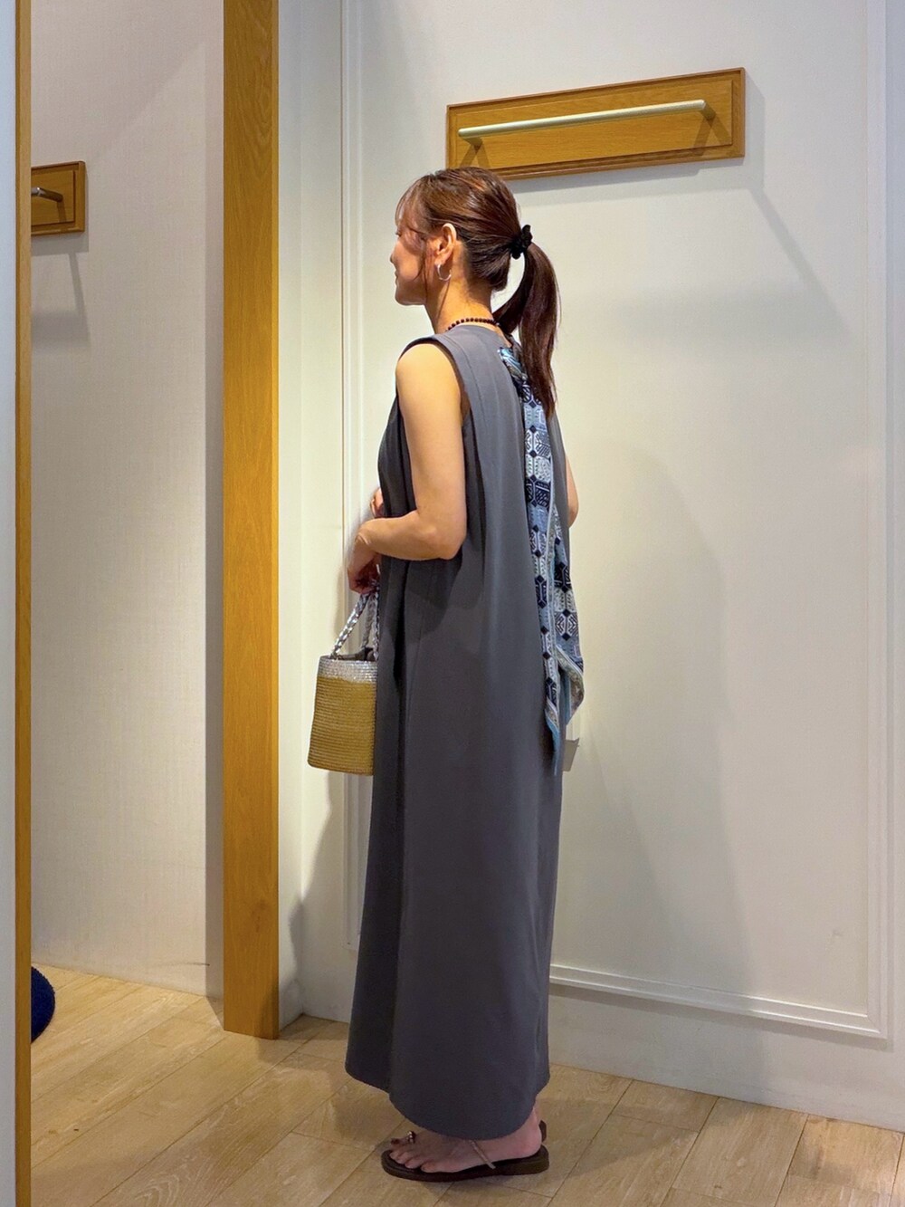 ベージュ系のカーディガン/ボレロ、グレー系のワンピース、ブラック系のネックレスを着用したレディースの夏コーディネートの6枚目の写真