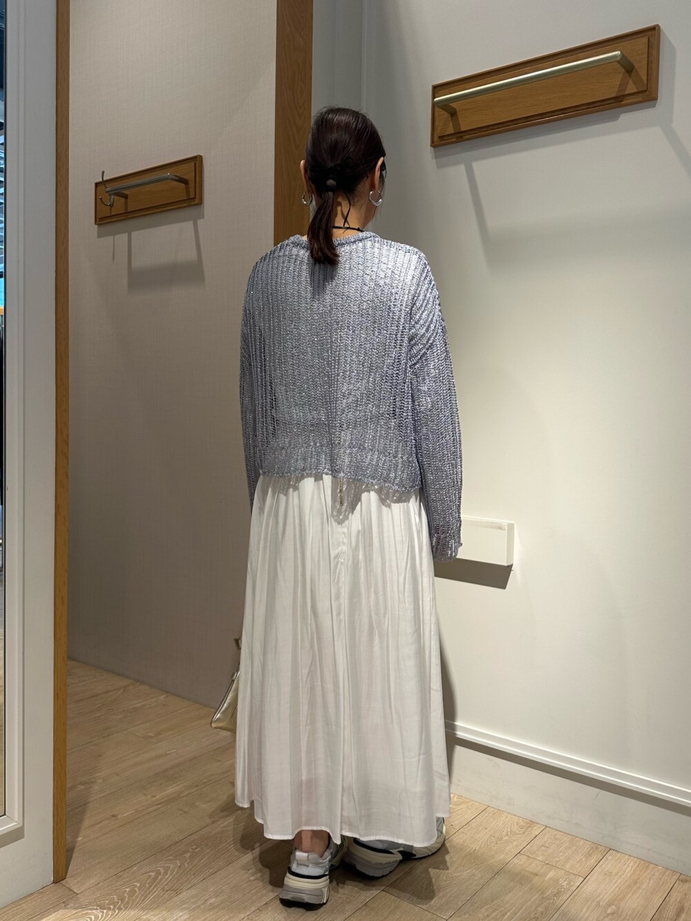 ブルー系のニット/セーター、ホワイト系のスカート、ホワイト系のTシャツ/カットソーを着用したレディースの冬コーディネートの2枚目の写真